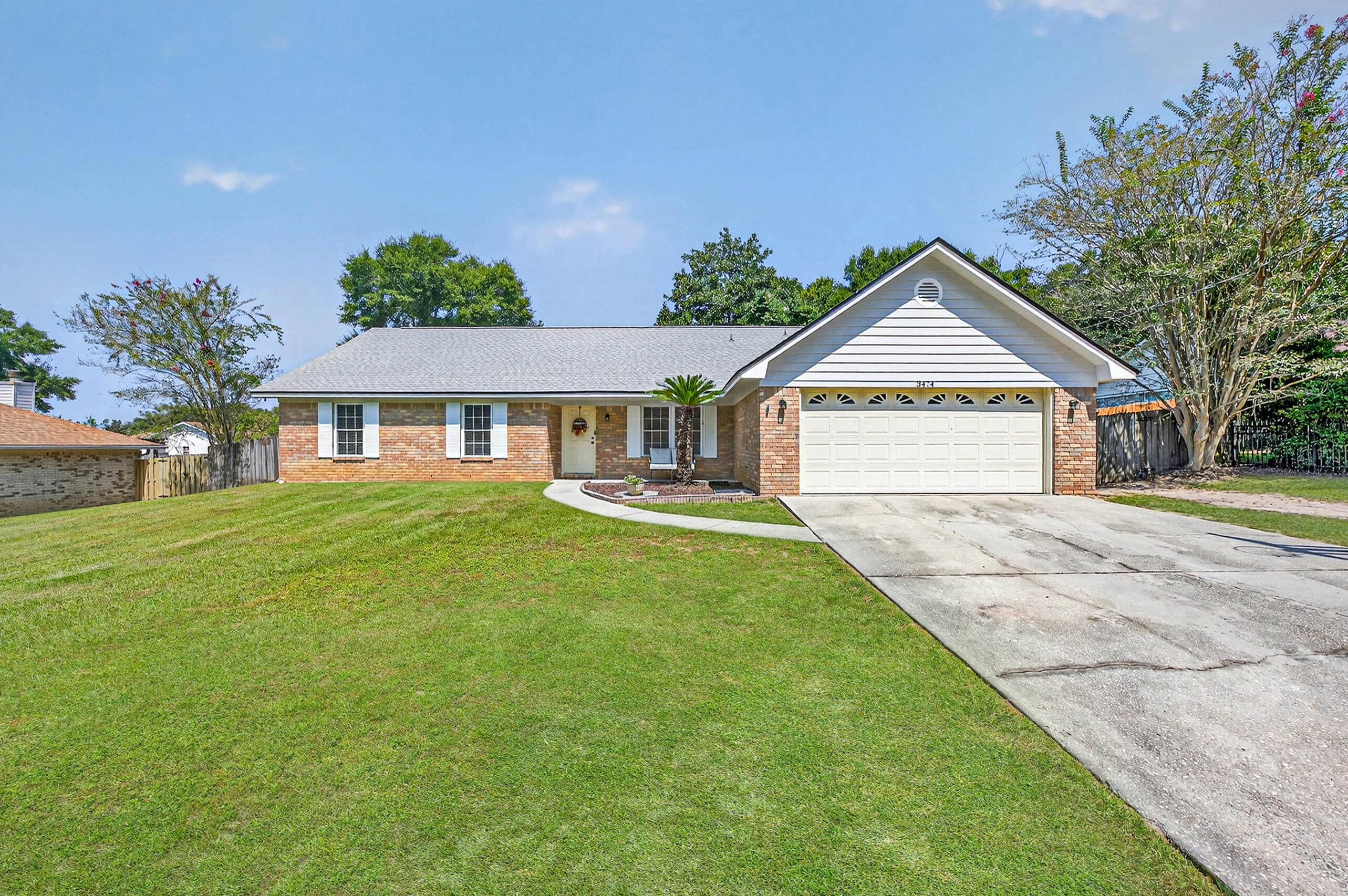 Welcome to this inviting family tucked in a charming neighborhood just off Woodbine Road with no HOA! There's room to park your boat or RV, giving you the freedom to enjoy all that Florida living has to offer. With a 2023 roof, 2022 HVAC, and 2026 water heater, the big updates are already taken care of! Step inside to a large formal dining room and an open living room with vaulted ceilings and a wood-burning fireplace. The kitchen is cozy with granite countertops, rich wood cabinetry, a pantry, breakfast nook, and a breakfast bar for extra seating. Just off the living room, the spacious sunroom is an extension of the home, filled with natural light and perfect for entertaining. The split floor plan provides a private retreat for the primary suite, complete with a spacious walk-in closet and en suite bath featuring a double vanity and tub/shower combo. Down the hall, three additional bedrooms offer flexibility for family or guests. One bedroom has its own full bath, ideal as a mother-in-law suite or private guest space, while the other two share a full hallway bath with a tub/shower combo. The backyard is fully fenced and features mature shade trees, offering a peaceful retreat for outdoor living. A patio is ready for grilling and entertaining, and a storage shed adds convenience.  Other features include a two-car garage, and spacious laundry room with cabinetry for extra storage. Well maintained and move-in ready, this home offers both comfort and functionality in a highly de sirable Pace location!