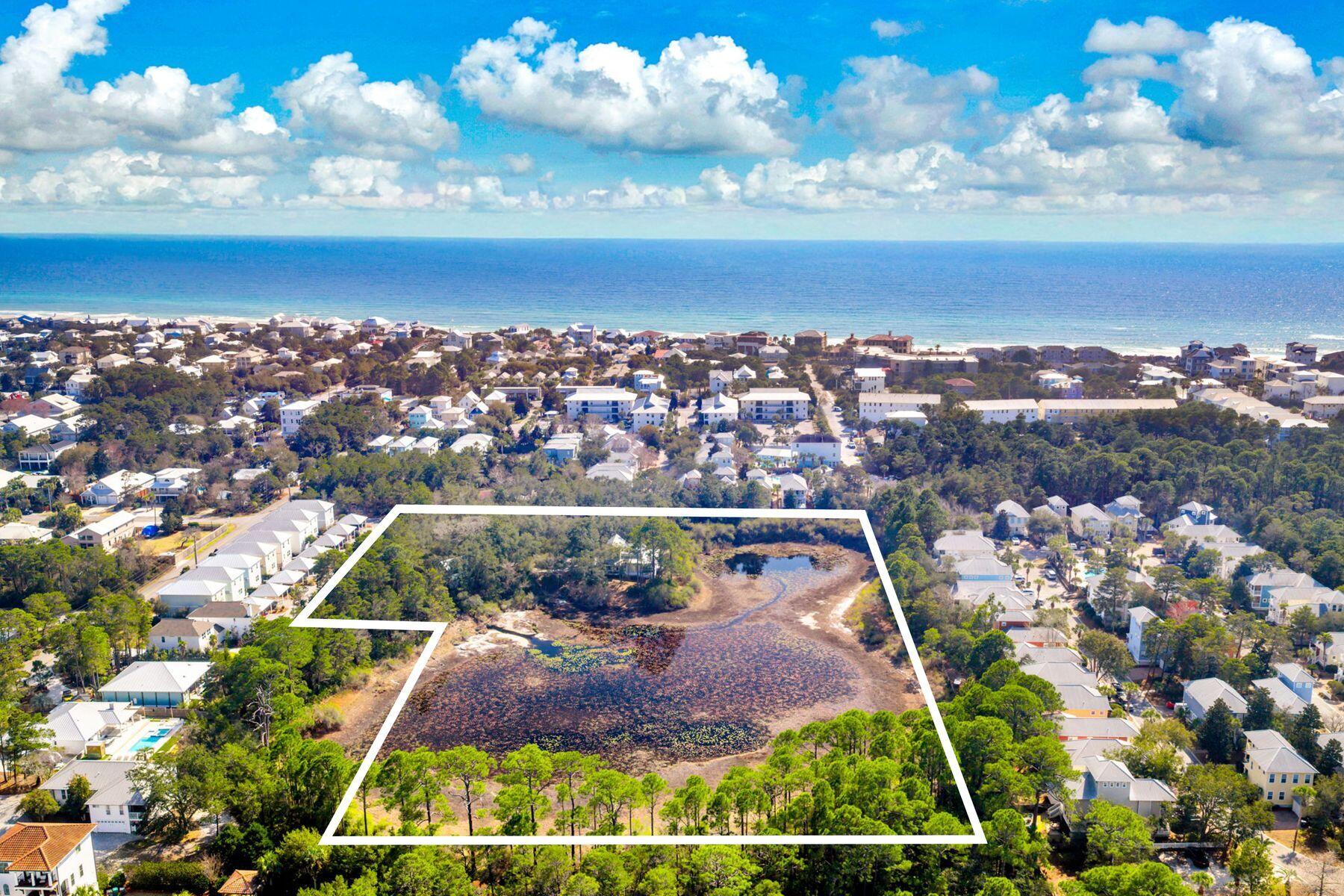 Seller financing considered...A rare six-acre private family compound in Blue Mountain Beach tucked away from the noise of the world, yet uniquely positioned only three blocks from the Gulf of Mexico and beach access, this extraordinary sanctuary is a living, breathing landscape. The compound boasts apprx 2.5 upland acres zoned NP Infill which allows up to eight structures per acre. The classic coastal cottage rests at the water's edge with a lake view from every room.  At its heart lies a three-acre spring-fed lake, its water so clear and still on quiet mornings that the ancient live oaks surrounding it see their own reflection. And those oaks draped in Spanish moss with cathedral arms are magnificent. Sitting beneath them is a charming 2200 sf coastal cottage that has been showcased in various magazines with