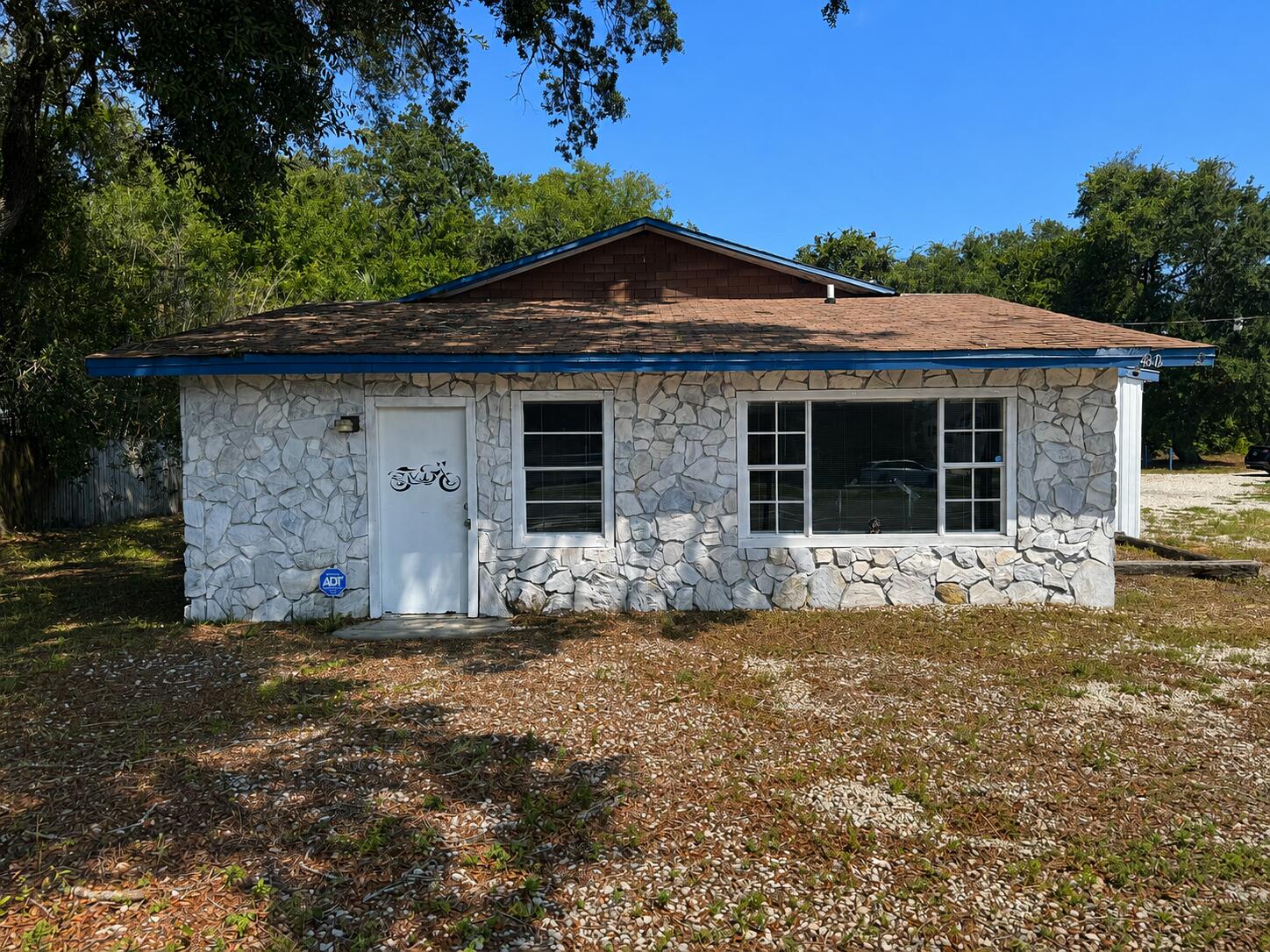 The building has a great foundation to build out whatever configuration you may need. Constructed of mostly cinder clock and rock, there is very little wood on the structure. 2 restrooms, a concrete slab floor, partial metal roof, partial shingles. There are 3 roll up bay doors. You could put in central heating/air. The ceiling is open so easy to add in duct work and electrical now before closing it up.  The lot has beautiful oak trees on it and the owner is willing to do seller financing!