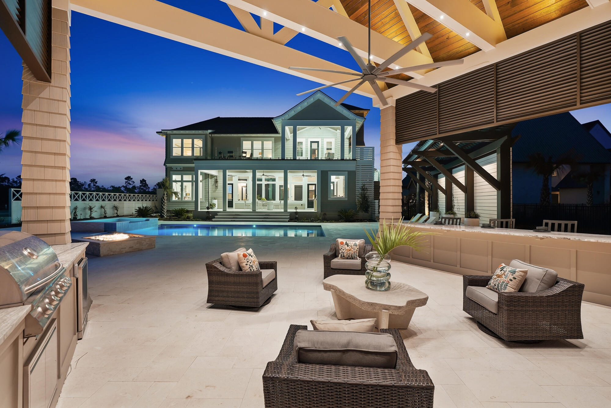 One of the newest custom estates in the prestigious gated community of WaterSound Camp Creek, where world-class golf, resort amenities, and timeless coastal architecture come together in a private retreat just minutes from the Gulf. Positioned along a tranquil lake encompassing approximately 8,700 square feet of total combined area, 460 GolfRidge Drive offers seven bedrooms, resort-style outdoor living, a private pool pavilion, and beautifully curated interiors designed for both everyday comfort and grand-scale entertaining.

This impeccable resort style residence includes 5,714 square feet of living area, 1,000 square feet of heated and cooled garage space, and an additional 1,986 square feet encompassing a pool cabana with full bath, covered porches and viewing terraces. Inside, the home's scale and natural light create an immediate sense of openness. Twelve-foot ceilings run throughout, while select spaces rise to vaulted heights of 15 to 18 feet, enhancing the airy, gallery like atmosphere. Seven inch engineered white oak flooring flows throughout the residence, complemented by custom white oak cabinetry and carefully curated designer lighting. Six of the home's seven bedrooms are positioned to capture tranquil water views, creating a serene backdrop that extends the home's connection to its surrounding landscape. At the heart of the home, an extraordinary Italian made all glass Chanel design chandelier cascades through the main living space like a piece of modern sculpture. Designed to capture and refract light from every angle, the chandelier becomes a breathtaking architectural focal point that anchors the room with unmistakable elegance and establishes the tone for the home's elevated interiors where architecture and artistry meet.

The primary kitchen pairs elegant design with exceptional functionality. Custom white oak cabinetry, dual 48 inch professional gas ranges, and a dedicated wine chiller and serving station anchor the space, while a nearby wine room with built in racks set against an oak feature wall offers a striking setting for displaying and enjoying a curated collection. Designed with collectors in mind, the wine room features custom oak storage for 154 individual bottles along with 18 case style compartments that provide additional space for expanding a thoughtfully curated collection. The adjoining living area centers around a gas fireplace, creating warmth and balance within the expansive gathering space.

Bathrooms throughout the home reflect the same attention to detail, featuring fully tiled showers, custom crafted vanities, and refined designer fixtures, while curated furnishings and finishes by John Richard introduce a tailored, design forward aesthetic.

Outdoor living unfolds across beautifully composed spaces designed for both relaxation and entertaining. A spacious sun terrace overlooks the heated pool and spa, custom pavilion, and tranquil lake views, framed by tempered impact glass railings that preserve unobstructed sightlines across the landscape.

Below, the backyard becomes a private retreat. White limestone pavers surround the pool deck, while a custom built gas fire pit creates a welcoming focal point for evenings outdoors. A striking vine covered pergola wall and extensive landscape lighting add depth and architectural texture to the outdoor setting.

The pool house pavilion extends the home's entertaining capabilities with a fully equipped outdoor living area featuring a 70 inch television, electric fireplace, Blaze stainless gas grill, bar refrigerator, and outdoor sink, along with a full bathroom and storage. A whole home Bose sound system provides seamless audio throughout the interior and outdoor living spaces, enhancing gatherings large or small.

Additional architectural details include Decra stone coated aluminum shake roofing, natural gas copper lanterns, insulated windows, a laundry chute from the second floor, central vacuum system, and a heated and cooled three car garage designed for both convenience and flexibility.

With its generous scale, exceptional craftsmanship, and beautifully integrated indoor and outdoor living spaces, 460 Golfridge Drive offers a sophisticated interpretation of coastal living where architectural integrity, designer finishes, and resort style amenities come together in one of 30A's most sought after private club communities.