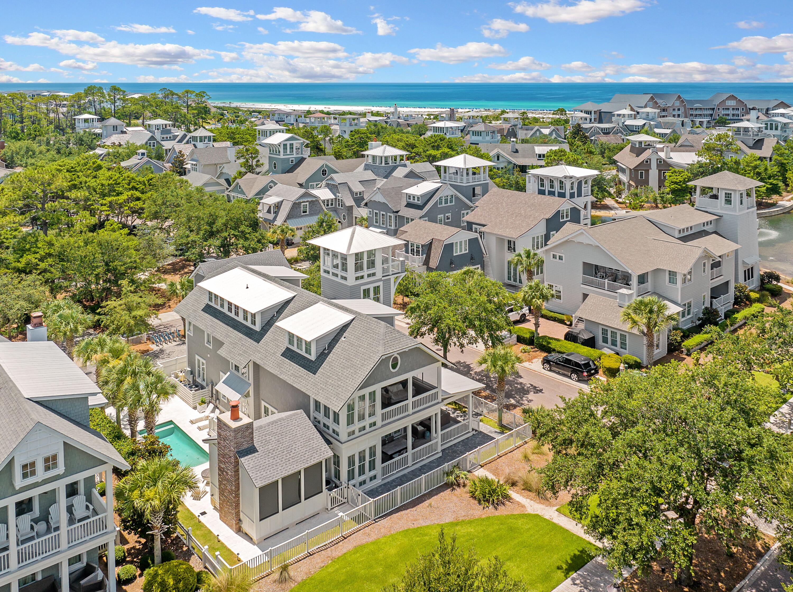 Positioned on a corner lot just south of 30A, this refined WaterSound Beach residence is a masterclass in elevated coastal living. Encompassing more than 5,100 square feet of conditioned space, including the connected pool porch cabana, this six-bedroom, six-and-a-half-bath home, along with a newly built carriage house, offers three distinct entertaining areas, each thoughtfully designed to accommodate gathering or retreat. A screened pool porch cabana with integrated air conditioning opens to a private outdoor sanctuary, complete with a large heated pool, fire pit, and summer kitchen, perfect for relaxed evenings under the stars on one of the larger lots in WaterSound Beach. The kitchen is a chef's dream, outfitted with Thermador appliances, a gas cooktop, leathered countertops, dual dishwashers, and a spacious center island. Just off the main living space, a serene primary suite features a dedicated sitting room and a luxurious bath with a deep soaking tub, a large walk-in shower, and artisan tile. Upstairs, three additional guest suites offer privacy and comfort, while the third floor hosts a sprawling bunk room with beds for 12, its own media lounge, and a private bath. A carriage house, completed in 2023, adds flexibility for hosting or extended stays. Additional features include reclaimed hardwood floors, tankless water heaters, a whole-home audio system, plantation shutters, designer lighting, and a second-level bed swing. This home enjoys all the privileges of WaterSound Beach, including deeded beach access to over 1 mile of private beach, two community pools, miles of boardwalks and trails, kayak rentals, and close proximity to The Big Chill, Alys Beach, and Rosemary Beach. Whether you're searching for a luxurious primary residence, a second home, or a high-performing rental, this property offers rare versatility in one of 30A's most exclusive gated communities.