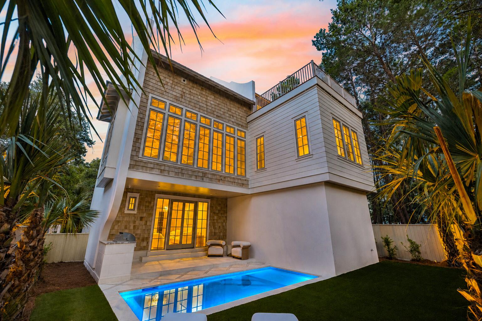 Set against a peaceful state forest backdrop, this new construction retreat by Focus Construction brings together refined coastal design, luxury finishes, and exceptional outdoor living. Located near Watersound Beach Club, The Big Chill, and the beach, 27 Chance Ln offers a rare combination of privacy, quality construction, and proximity to some of the area's most desirable amenities.

The exterior makes an immediate impression with a concrete finish, cedar shake accents, oversized windows, lush landscaping, landscape lighting, exterior gas lanterns, Ipe decking, and a private heated pool surrounded by peacock pavers. Outdoor living continues with a summer kitchen, turfed green space, and a third-floor balcony overlooking the state forest complete with a wet bar and gas fire feature.

Inside, expansive windows fill the home with natural light while custom cabinetry, solid core doors, and poplar wood ceiling accents create a warm, elevated feel throughout. The first floor features 10-foot ceilings, peacock paver flooring, a guest bedroom, den, and direct access to the pool area. The second floor offers 11-foot ceilings, European white oak wide plank hardwood floors, the main living area, dining space, kitchen, and primary suite.

The chef's kitchen is finished with Thermador and KitchenAid commercial-grade appliances, custom cabinetry, and Taj Mahal leathered quartz countertops. The third floor includes additional guest accommodations, custom built-in bunks sleeping four, and a state forest-facing outdoor living area designed for relaxing or entertaining under the stars.

Thoughtfully designed across three levels, the home offers both everyday comfort and elevated entertaining spaces. A 2-car garage with electric car charger prewire adds convenience, while sound and security prewire bring modern functionality. With new construction, high-end finishes, a private heated pool, and a peaceful setting near the beach, Watersound Beach Club, and The Big Chill, 27 Chance Ln offers a standout opportunity in the Camp Creek area.