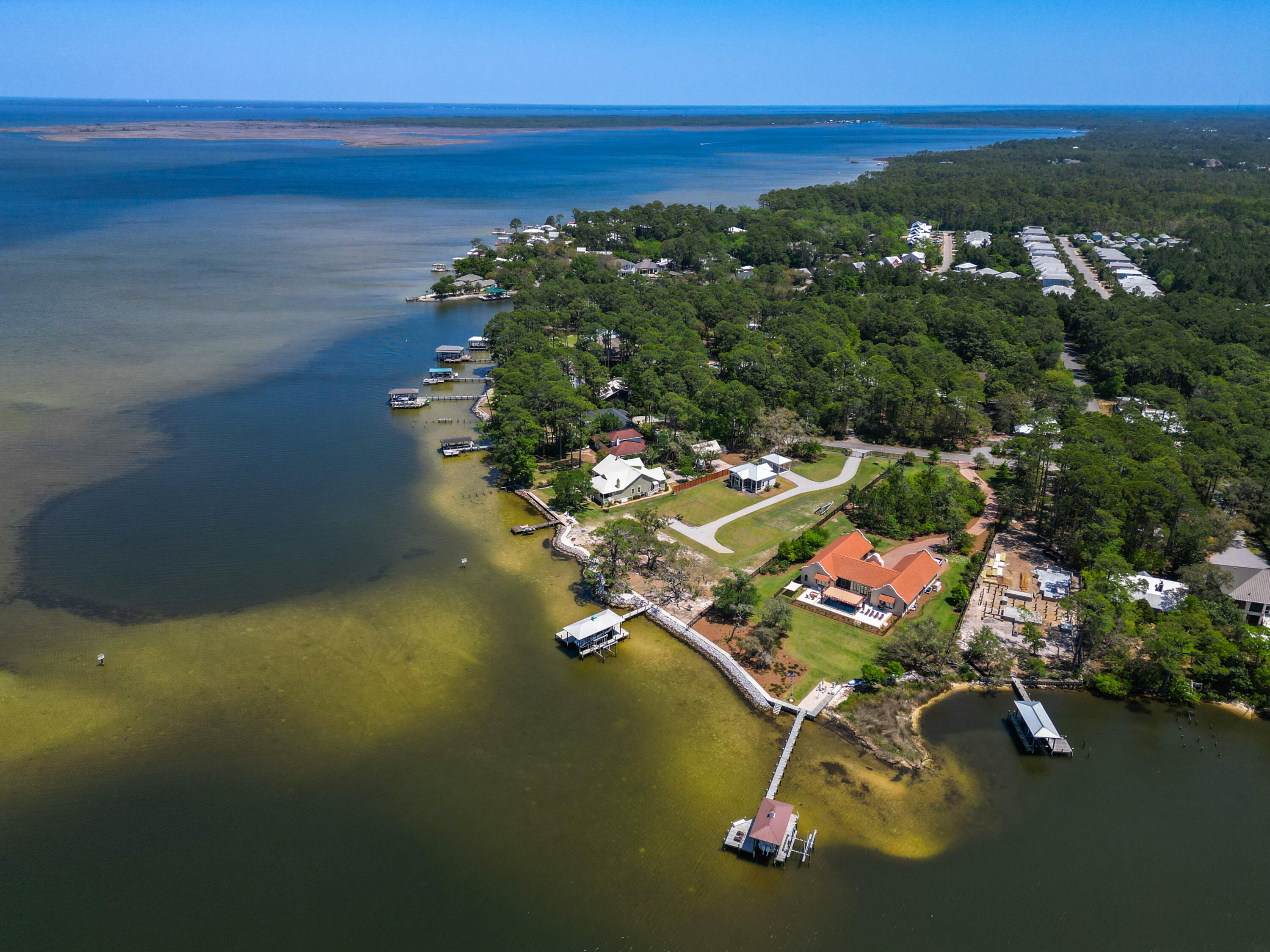 Set behind a private gated entry, this exceptional 1.47-acre property on Hewett Bayou offers over 200 feet of pristine bay frontage, delivering direct deep-water access and an unrivaled waterfront lifestyle. With no HOA restrictions and the flexibility of a rare double lot, this property is ideal for boaters, nature lovers, and those seeking space and serenity along the coast. One of the last west-facing, deep-water opportunities available on the Choctawhatchee Bay, the homesite captures breathtaking sunset views across open water--an increasingly rare chance to secure a premier waterfront setting with both privacy and navigable depth. The property is thoughtfully improved with an exceptional marine infrastructure designed for both performance and longevity. The expansive dock features composite decking, a lower flow-through platform, two boat lifts, and a covered boathouse capable of accommodating vessels over 30 feet. A durable vinyl sheet seawall, reinforced with substantial riprap, provides long-term shoreline stability and protection for decades to come. The expansive grounds offer endless possibilities for a custom main residence, pool, and guest quarters, all positioned to take full advantage of sweeping water views and coastal breezes. Whether casting a line from the dock, kayaking at sunrise, or enjoying the abundant wildlife, life here moves to the natural rhythm of the bay. A charming two-bedroom, two-bath carriage house currently occupies the property--ideal for immediate enjoyment or as a comfortable retreat while you plan your vision for a future estate. This is more than a property--it is a rare opportunity to create a legacy waterfront compound on one of the Choctawhatchee Bay's most desirable west-facing, deep-water homesites.