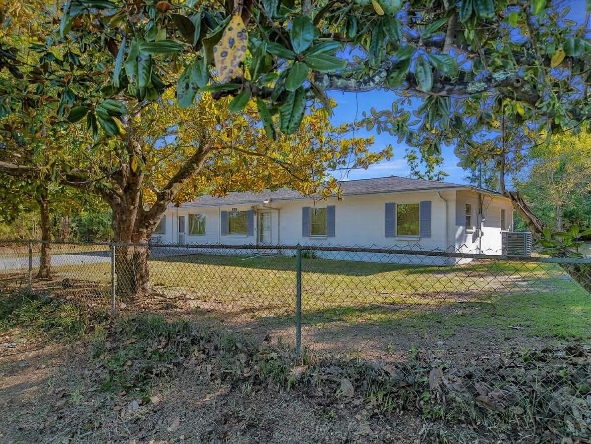 No HOA, 1 Acre of land, 4 bed 2.5 bath, block home! Discover the perfect blend of modern living and rural freedom in this well-maintained concrete block home, nestled on a peaceful, wooded one-acre lot in the heart of Bayou George. With no HOA restrictions, this property offers true independence, featuring a cleared area around the home ideal for parking boats or RVs, complemented by a back concrete patio and separate outbuildings for all your storage needs. The spacious 1,664+ square foot interior boasts an open-concept layout with four bedrooms, 2.5 bathrooms, and attractive hardwood-look tile flooring throughout. The chef-ready kitchen is equipped with a gas range, stainless steel appliances, and stylish barn doors, while a generous walk-in laundry room and gas tankless water heater add modern convenience. Key high-value extras include a private deep well with a Culligan water softener, a 250-gallon in-ground propane tank, and an active AC maintenance agreement with Peaden for added peace of mind. Located just a short drive from the boat ramps at Deer Point Lake and the amenities of Panama City via Highway 231, this move-in-ready gem is the ideal sanctuary for those seeking a wooded retreat with city accessibility. Schedule your showing today!