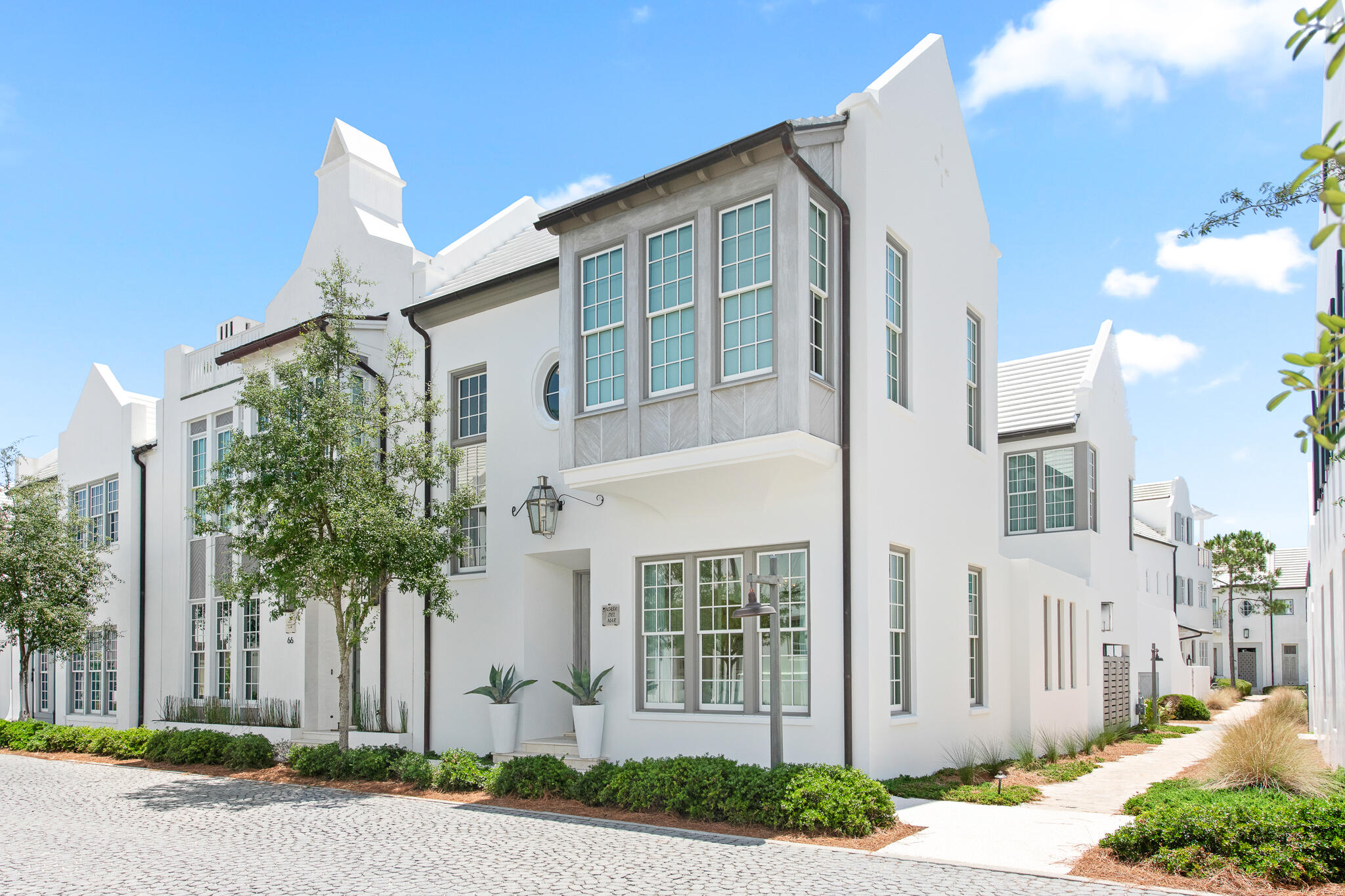 This Domin Bock designed courtyard home is located on a corner homesite bordered by a pedestrian path, allowing for natural light on three sides. The first level features an open living, dining, and kitchen area with large bifold doors that open directly to the private courtyard.
The courtyard includes a pool with fountain, creating a functional outdoor living area for entertaining or everyday use. The first floor also includes a powder room, laundry area, and a two-car garage.
Interior finishes include quartzite, Venetian plaster, honed marble, mother of pearl tile, and high-end appliances. The second level includes a flexible bedroom with vaulted, beamed ceilings, Pecky cypress detail, a private bath, and bay window. Two additional guest bedrooms include en suite baths and windows overlooking the courtyard and pool.
The primary suite features Venetian plaster walls, vaulted ceilings with beams, a sitting alcove, and a large walk-in closet. The primary bath includes a freestanding soaking tub with a herringbone mother of pearl tile wall, marble shower, and double vanity.
Located in one of the more established areas of Alys Beach, the home offers convenient proximity to Caliza Pool, ZUMA Wellness Center, the Nature Trail, and the town center.