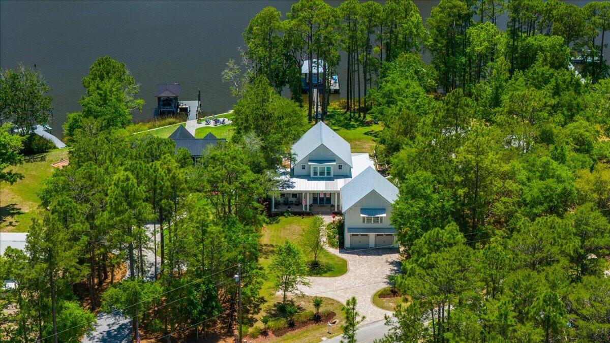 BAYOU FRONT WITH BOAT DOCK! This coastal custom home is set on a protected bayou with serene water views. Enjoy your private dock which has $36k of upgrades that include a lift for a boat and 2 jet skis. The apartment above the garage offers versatility for an Airbnb or office. Enjoy Southern charm with brick pavers throughout, high ceilings, deep covered porches, including a 24x16 rear porch, and a fenced backyard with a small citrus grove. As a bonus, a 26kw whole-home generator supports both structures and the dock with 2 owned propane tanks. The main home offers 3bed/3.5 baths and a downstairs primary suite with a modern closet, soaking tub, and separate shower. The kitchen showcases an oversized island, gas range and extra storage in the kitchen galley. No HOA & room for a pool! Don't miss out A beautifully pavered driveway leads to the 2-car garage with a apartment above--complete with private bedroom, living area, bathroom, and kitchenette, ideal for rental income, guest suite, or office.

Located within easy reach of 30A, Blue Mountain Beach, and Grayton Beach, easy boating to North Beach and The Bay restaurants or head to Crab Island in Destin--perfect as a primary residence, second home, or investment opportunity.