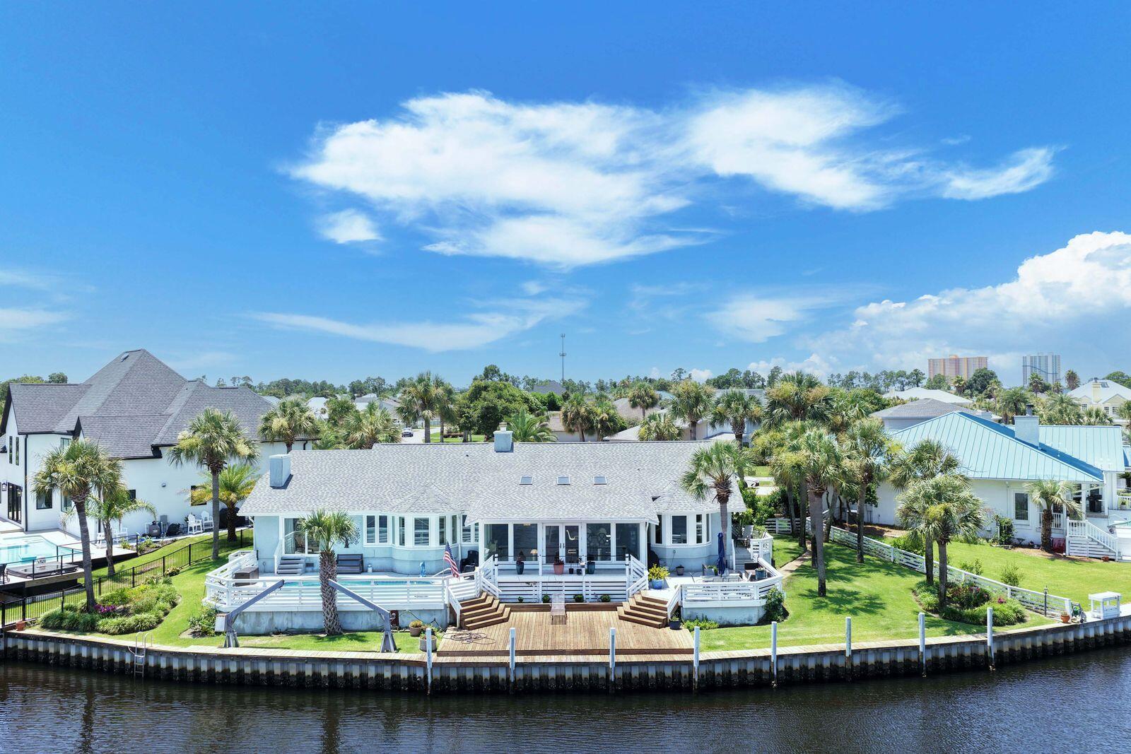 Welcome to the coastal life! Come experience some of the best waterfront views in all of Bay Point! Situated on a premier waterfront homesite with approximately 149 feet on one of the widest sections of the canal, this beautiful property offers panoramic water views. This is the perfect setting for the ultimate coastal lifestyle, where you can keep your boat at your backdoor and be ready to go fishing and boating at a moment's notice. Enjoy the large waterfront deck and sparkling pool, where you'll spend countless hours relaxing, entertaining, and taking in the incredible canal views. This spacious home features over 3,300 square feet, 3 bedrooms, and 3 full baths all on one level for easy living. The expansive primary suite is a private waterfront retreat with a sitting area, oversized walk-in closet, and en-suite bath. Each of the two additional bedrooms offers its own private bath, providing comfort and privacy for family and guests. The open-concept floor plan is ideal for entertaining, featuring views from literally almost everywhere, tons of natural light, generous living spaces and entertainment spaces as well as a built-in bar, making this home perfect for hosting and enjoying family and friends. Located within the prestigious gated community of Bay Point, residents enjoy world-class amenities including the Jack Nicklaus Championship Golf Course, a full-service marina, on-site restaurant and bar, and 24-hour gated security. You are ideally located and convenient to St Andrew's State Park, white sandy beaches, grocery, shops and restaurants and more. This is a rare opportunity to own a home on a premier waterfront homesite in Bay Point. Call today and make this your next home!