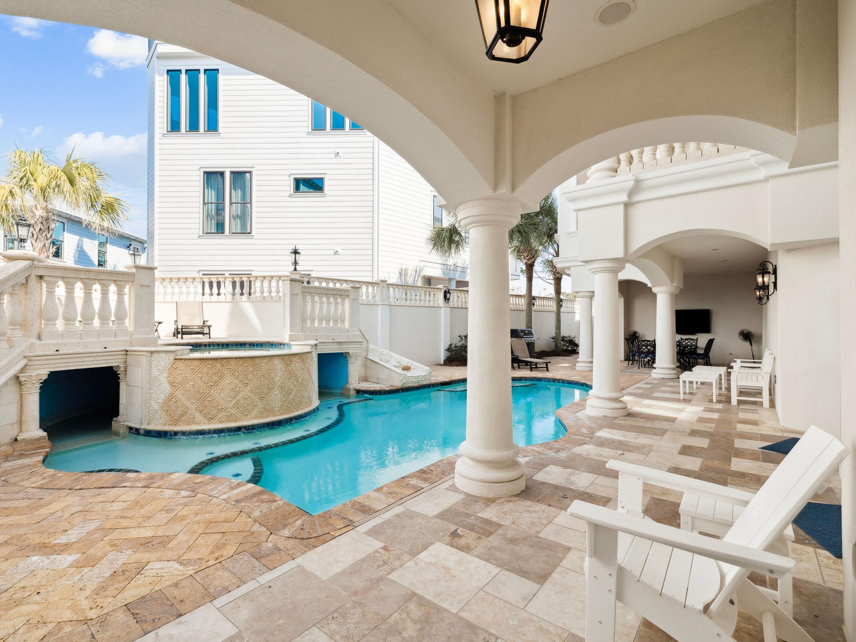Positioned within the gated enclave of Pelican Circle along Scenic Highway 30A, this exceptional coastal residence offers a rare opportunity just moments from the Gulf's white sand shoreline and the rare coastal dune waters of Camp Creek Lake. Tucked behind private gates and set within one of the area's most discreet beachside corridors, the property pairs architectural presence with a location defined by both exclusivity and natural beauty. Spanning more than 5,500 square feet, the home is thoughtfully designed to balance expansive gathering spaces with private retreats, all oriented to capture sweeping views and seamless indoor-outdoor living. An elevator provides effortless access to each level, ensuring both convenience and long-term livability without compromise. In 2025, the residence underwent a comprehensive interior refresh, including full interior repainting, all new designer furnishings, updated lighting throughout, and new pool equipment, enhancing both its aesthetic appeal and operational performance.

The arrival experience is both striking and intentional. A circular drive and custom pergola frame the approach, leading to a dramatic iron entry. Inside, soaring ceilings and generous proportions create an immediate sense of scale. The first floor is designed with both entertainment and functionality in mind, featuring a spacious bunk room ideal for hosting multiple guests and a dedicated movie theater that transforms evenings into a private cinematic experience.

At the center of the outdoor living experience, a secluded courtyard is enclosed by a tall stone wall, offering privacy rarely found this close to the beach. A heated pool and spa, complemented by a built-in grotto and cascading waterfall, create a resort-style setting equally suited for quiet mornings or elevated entertaining.

The second level introduces the main living space, anchored by a chef's kitchen and dining area designed for gathering. Multiple balconies extend the living areas outward, capturing Gulf views from the front and serene pool views from the rear. Two additional king suites share a well-appointed bath with a walk-in shower and dressing area, providing comfort and privacy for family or guests.

On the top floor, a glass-enclosed fitness room, secondary laundry, and powder bath add convenience and flexibility. A guest primary suite enjoys its own private balcony and spa-inspired bath, while the main primary suite commands the home's most compelling Gulf views. Complete with an expansive terrace, custom dressing room, heated bathroom floors, soaking tub, and walk-in shower, it serves as a true private sanctuary above the coastline.

Primely positioned within gated Pelican Circle, just steps from the beach and minutes from the natural beauty of Camp Creek Lake, this recently refreshed residence offers a compelling blend of lifestyle, privacy, and long-term value. With exceptional scale, resort-caliber amenities, elevator access, and meaningful upgrades completed in 2025, it represents a rare offering along 30A for those seeking refined coastal living with enduring investment potential.