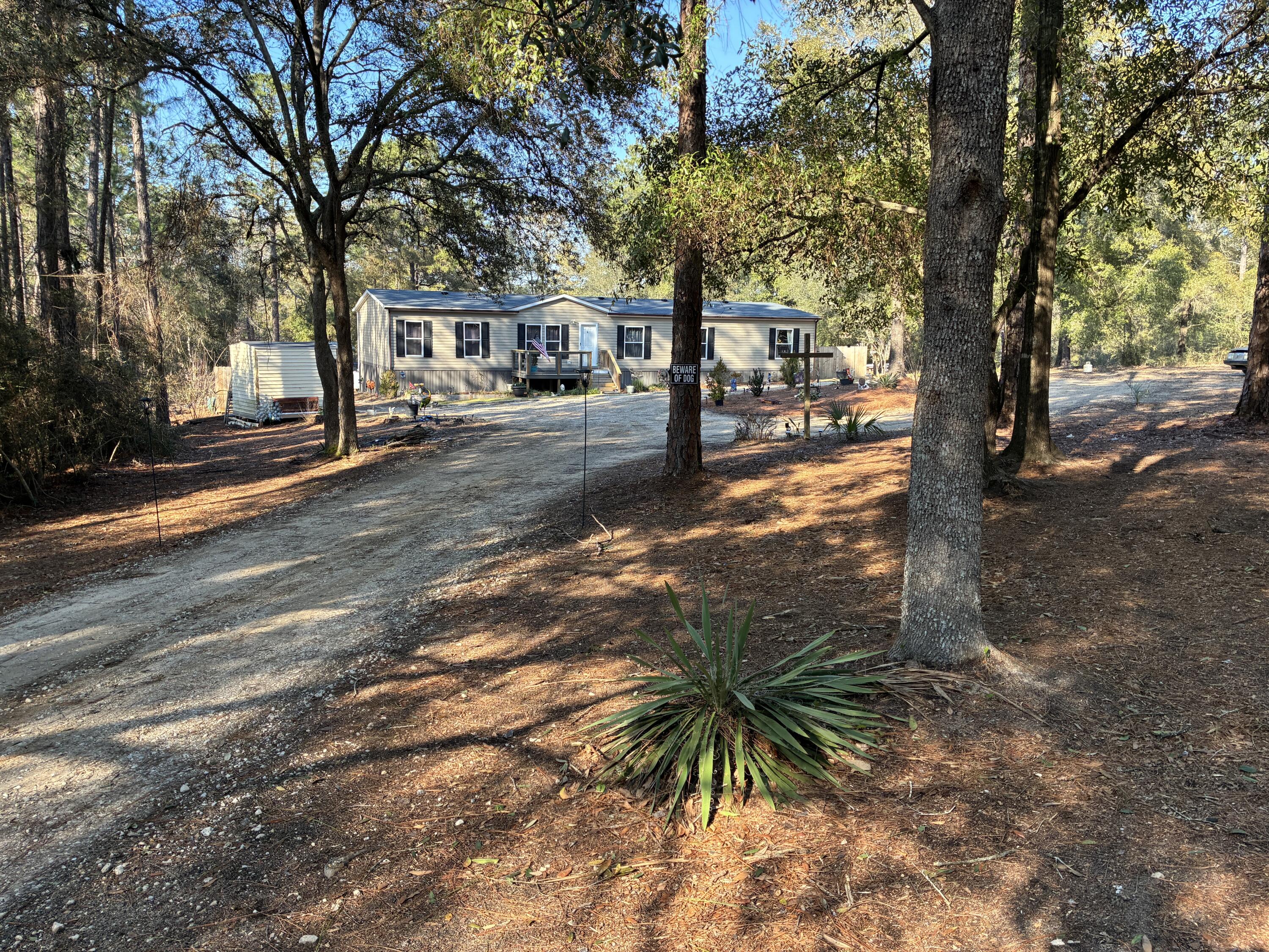 HIGH & DRY / Flood Zone X / Zillow's Flood Zone Info below is INCORRECT. Secluded paradise at the end of a private, gated, crushed concrete drive, where 5.84 ac. of Florida wilderness meets a meticulously maintained homestead designed for true self-sufficiency. This is more than a home; it's a private ecosystem featuring fruit trees and 1,261' of a KINGS LAKE FED CLEAR CREEK. The creek and orchard are a homesteader's dream. There's a massive variety of mature fruit and nut trees including Asian Plum, Guava, Fig, Peach, Cherry, Pear, Citrus, and more. Complemented by raised garden beds, a greenhouse, and a pro composting system plus extras. Features maintained ATV riding trails with jumps & mini golf. $10k Culligan water filtration. Large, powered shop / studio. Perm. Attached MH. Must see