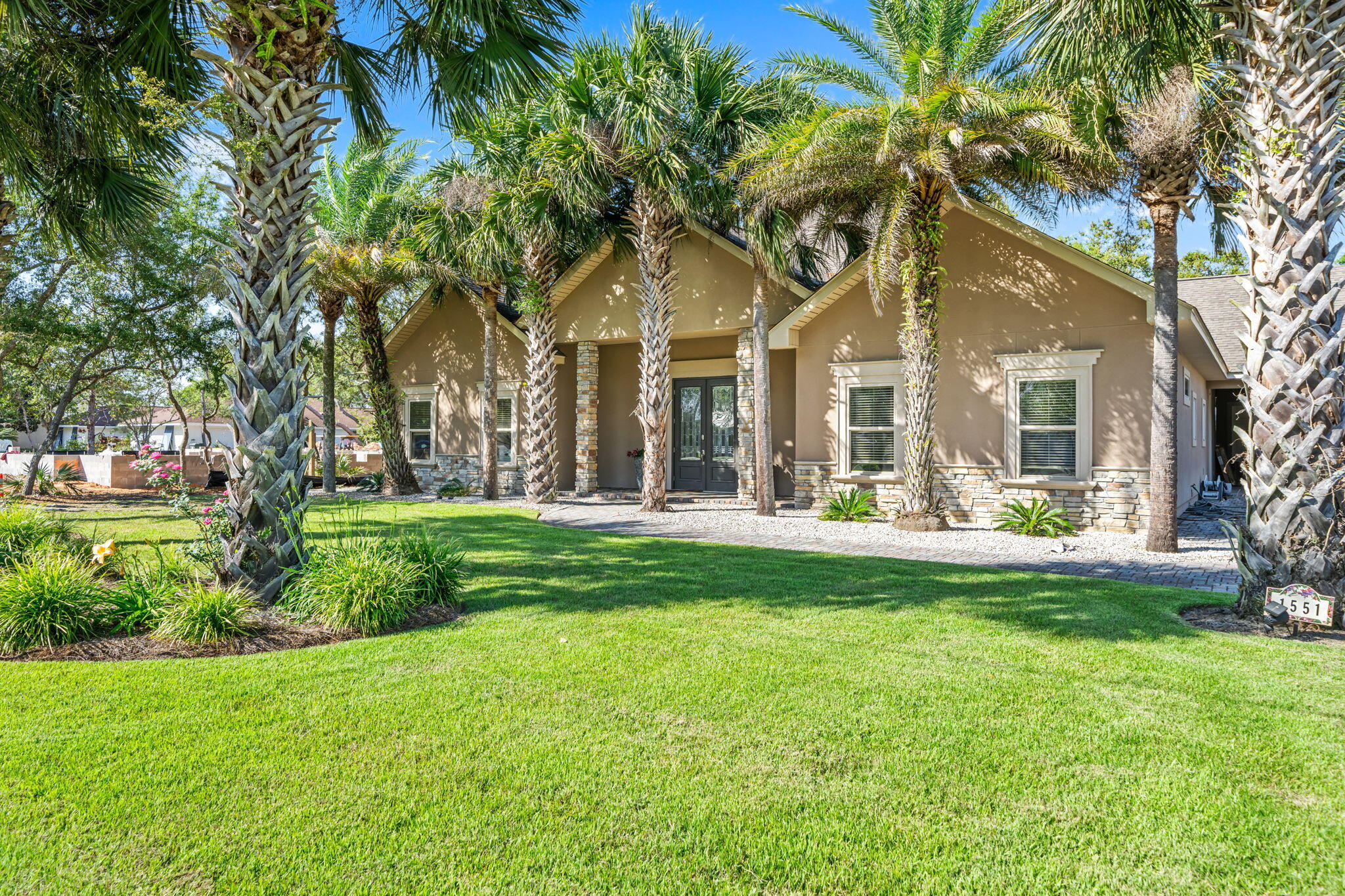 A rare chance to own on the water in Santa Rosa Beach's established Hatchee Shores community. This nearly half-acre homesite delivers 100 feet of bay frontage and a private dock with unobstructed open-bay views, making it the kind of setting made for boating, fishing, or simply watching the sun go down.

The home itself spans 3 bedrooms and 3 bathrooms across a well-maintained, light-filled floor plan built for easy coastal living. Mature palms shade the home's stone-accented façade, while a brick paver driveway and double glass entry, flanked by stone columns, set an elevated first impression.

Inside, hardwood and tile flooring flow throughout, complemented by crown molding and a stacked-stone fireplace that anchors the great room. The primary suite offers a spa-inspired bath with soaking tub, dual vanities, stone counters, and a walk-in tile shower.

Outdoor living is equally impressive: a covered back porch beneath grand live oaks, an outdoor shower, carport, and attached garage, plus a detached workshop/storage building for gear, hobbies, or extra storage.

Whether you're seeking a full-time residence, a second home on the water, or an income-producing property, this one checks every box, and it's all just minutes from 30A's sugar-white beaches, top dining, and boutique shopping.