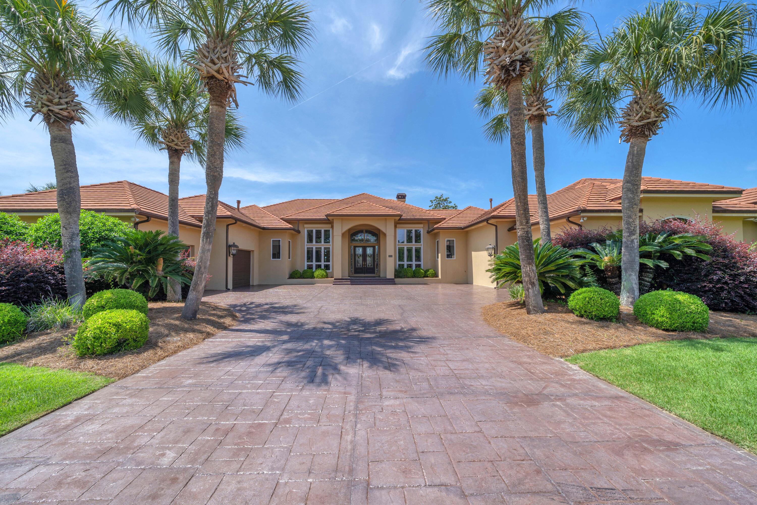 Discover 3500 Dragon's Ridge Road, an exceptional estate home that perfectly blends luxury, comfort, and durability in a breathtaking golf course setting within the gated community of Bay Point Legend Hills. Situated on a rare double lot, this custom-built, one-owner residence offers more than 4,600 square feet of thoughtfully designed living space all on one level, featuring soaring 10- to 16-foot ceilings, abundant natural light, Andersen windows and doors, solid core doors, crown molding, plantation shutters, and quality craftsmanship throughout. Stunning curb appeal welcomes you home with beautiful landscaping and wide driveway, concrete tile roof, and oversized three-car garage. Inside, enjoy expansive views of the 10th hole, 11th fairway, picturesque ponds, and unforgettable sunsets from the moment you enter. The spacious layout includes elegant living and dining rooms, a private office, and a gourmet kitchen equipped with Thermador appliances, Sub-Zero refrigerator, induction cooktop, Bosch convection microwave, Viking warming drawer, and an inviting family room with fireplace and custom wood feature wall opening to the outdoor living area. The resort-style backyard is designed for relaxing and entertaining with a sparkling pool, spa, covered patio, and fenced pool deck overlooking the golf course and water views. The private primary suite serves as a true retreat with a sitting area, oversized walk-in closet, dressing area, and recently updated bath featuring dual vanities and a custom wheelchair-accessible walk-in shower, along with direct access to the pool and hot tub. Two guest bedrooms with en-suite baths, a walk-in laundry room, and guest half bath complete the main living wing. A separate private wing offers incredible flexibility with a dedicated media room featuring projector screen, bar area, wine cooler, bonus living space, exercise room, full bath, private entrance, and oversized one-car garage/workshop, making it ideal for a mother-in-law suite or guest quarters. Additional highlights include four HVAC units replaced within the last five years, two gas water heaters replaced in December 2025, whole-house generator, roll down hurricane shutters, and gas furnace for year-round comfort and peace of mind. Residents of Bay Point enjoy resort-style amenities including a Jack Nicklaus-designed championship golf course, full-service marina, dining and entertainment at Bar 72, and convenient access to boating, shopping, dining, top-rated schools, and the sugar-white sands of Panama City Beach. This remarkable legacy property offers the perfect combination of elegance, functionality, and coastal lifestyle living.  Call today for your private showing!
