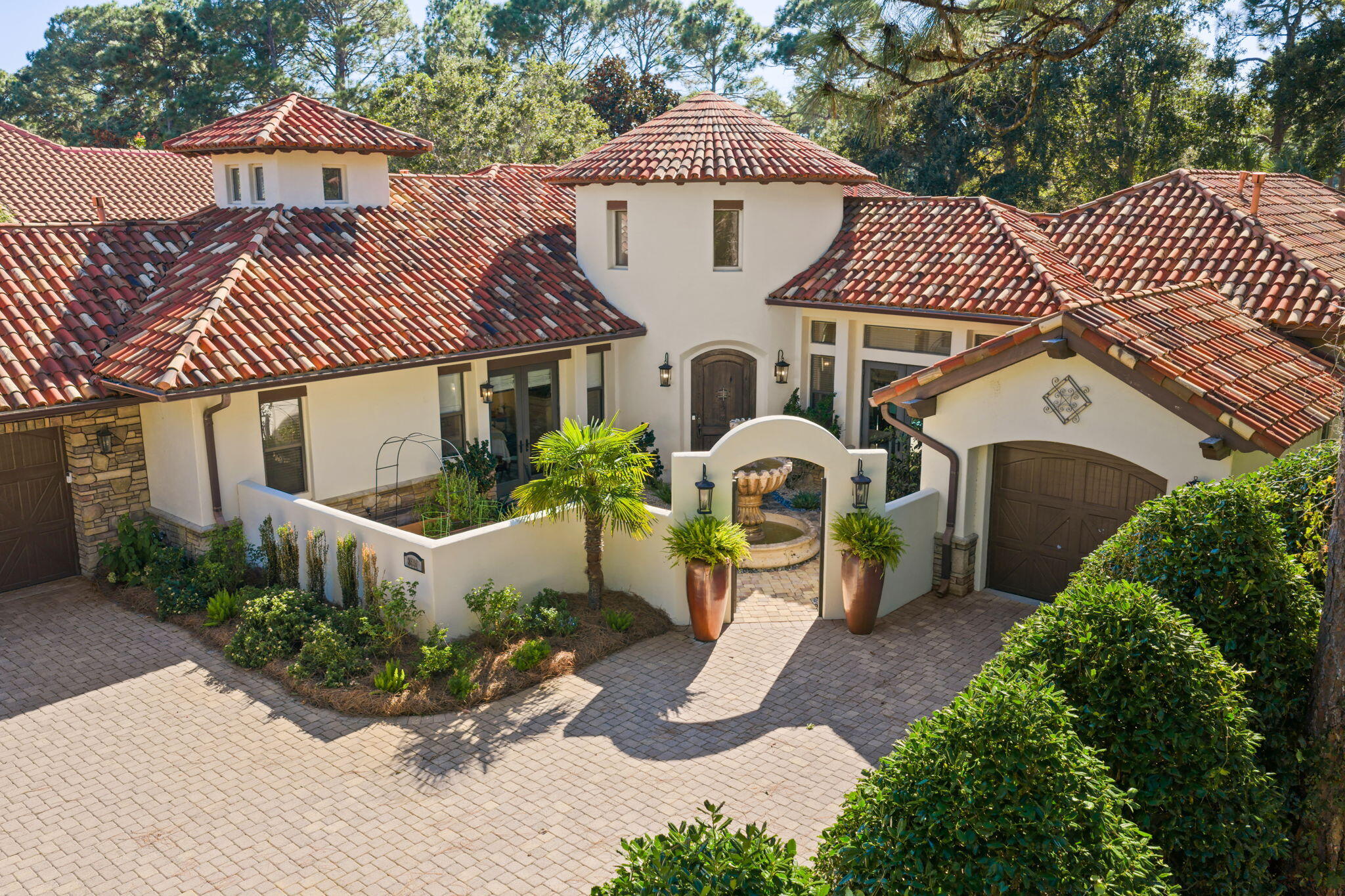 This exquisite custom-built, sprawling, single  story home is truly one of a kind. Tucked away on a prime, estate sized lot and cul-de-sac, located in the gated neighborhood of Burnt Pine and on the 2nd tee box of the Burnt Pine Golf Course, is a Tuscan inspired treasure. At   3,949 sq. ft., 3 beds, 5 baths, plus office, built by Sweet Homes as the builder's residence, the finishes are beautifully extraordinary. The many authentic wooden beams and wood planked ceilings are a timeless feature and from the illuminated brick covered barrel hallway ceiling to the stone accent walls, it is a showplace of craftsmanship and architectural design.  Enter by an arched courtyard gate that leads to a tranquil, cascading fountain.