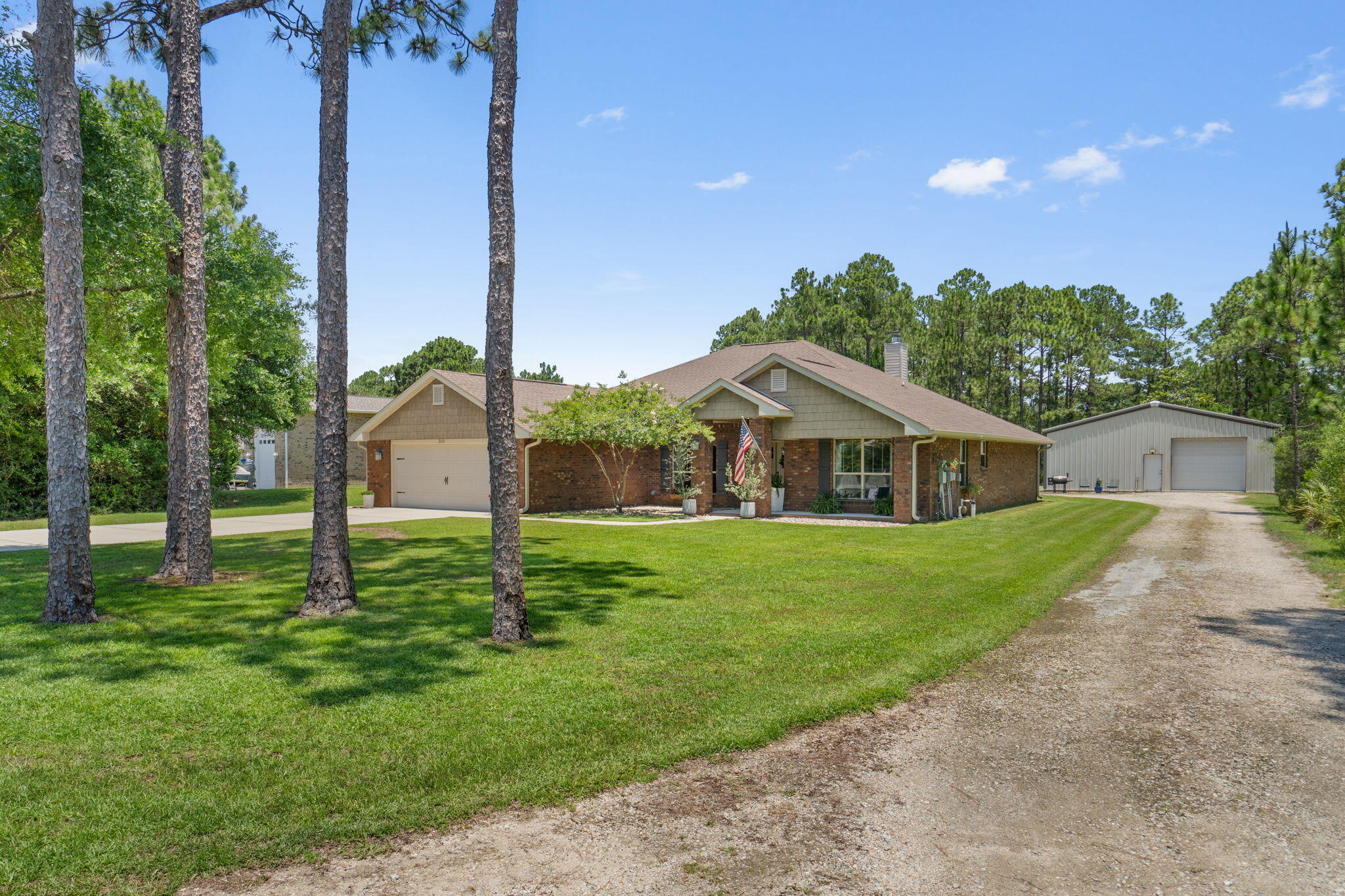 Impeccably maintained and move-in ready, this all-brick Craftsman-style home is tucked away on a beautiful full-acre lot in East Bay River Estates with no HOA. A standout feature is the impressive 40x50 (2,000 sqft) workshop, complete with two garage doors, two entry doors, and its own dedicated driveway - perfect for storing boats, RVs, vehicles, equipment, or creating the ultimate workspace! Inside, you'll find 4 bedrooms, 3 bathrooms, and a highly desirable split-bedroom floor plan, plus two versatile flex rooms at the front of the home that can serve as an office, formal dining room, playroom, or additional living space to suit your needs. The spacious family room features a cozy tile fireplace and opens to a covered 9x23 back porch with access from the family room, primary suite, and hall bath, creating an ideal layout for a future pool. The primary suite offers a relaxing retreat with a garden tub, separate shower, dual vanities, and separate walk-in closets with custom built ins. Recent upgrades include textured plank tile flooring throughout the main living areas, premium carpet in the bedrooms, extra-wide baseboards, custom window casings, additional interior wall insulation, updated lighting and ceiling fans, hurricane blinds, rain gutters, and a new water heater (2025). The kitchen features an updated sink, new dishwasher, and a 9-stage reverse osmosis/UV water filtration system. Additional highlights include underground electric service, an irrigation well and extended driveway parking. If you've been searching for a meticulously cared-for home with exceptional curb appeal, flexible living space, a massive workshop, and room to spread out without HOA restrictions, this property is a must-see.