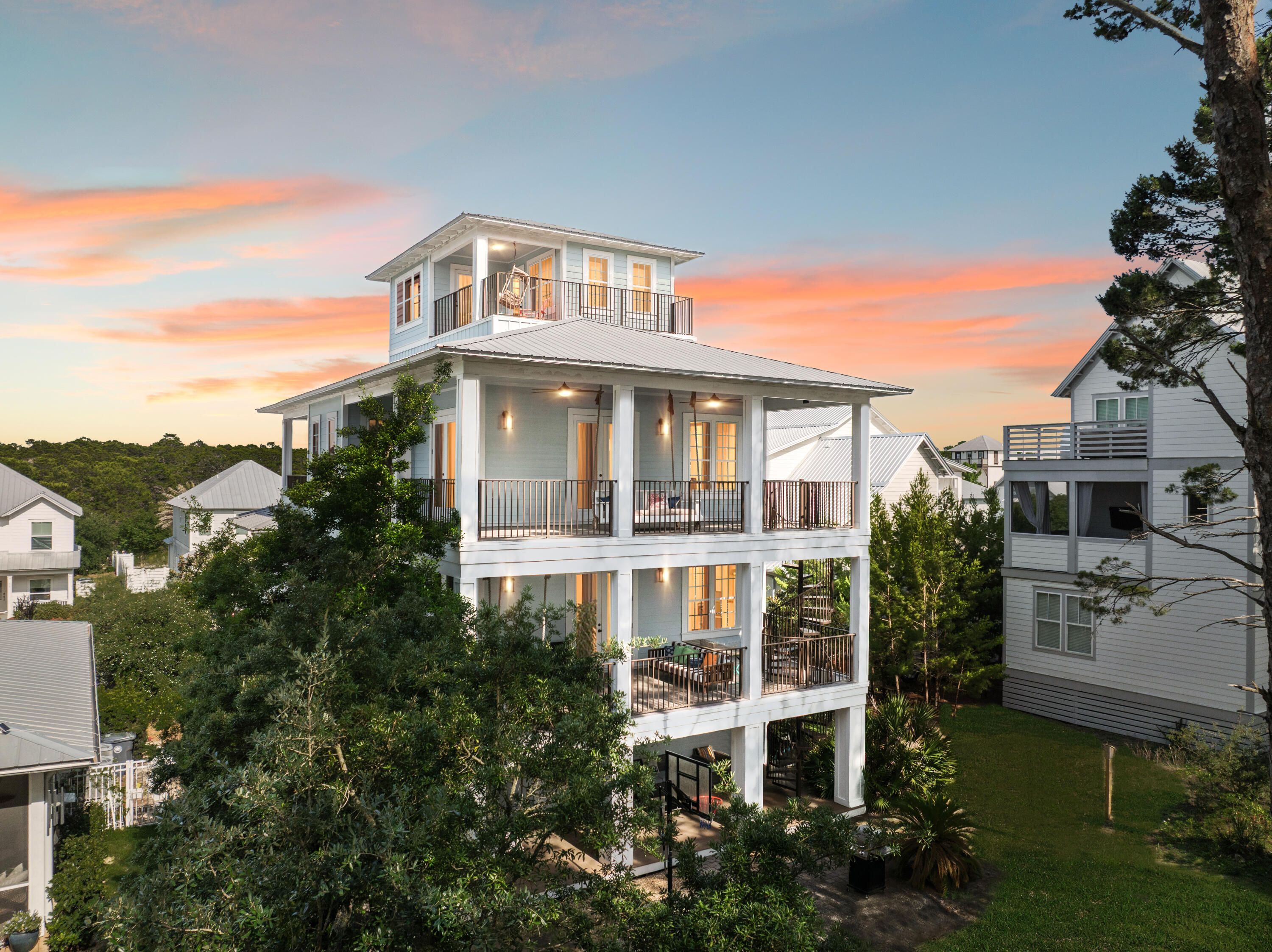 Nestled on a quiet street in the sought-after Grande Pointe community, this four-story beach home in Inlet Beach is the ultimate vacation destination for large groups. Boasting five bedrooms, five bathrooms, a bonus bunk area, and over 3,000 square feet of living space, this coastal residence offers an ideal blend of luxury, comfort, and functionality.
From the moment you arrive, you'll appreciate the thoughtful design, including an elevator for effortless access to all levels. The ground floor features a charming bunk room with a full bath, direct access to a covered patio, and a spacious, fenced backyard—perfect for relaxed barbecues or a friendly game of basketball on the paved court. The second floor showcases an open-concept living space adorned with soaring ceilings, hardwood floors, and designer lighting. A spacious living room, dedicated dining area, and gourmet kitchen create a welcoming environment for entertaining. The kitchen is fully equipped with an electric cooktop, double oven, custom range hood, wine refrigerator, and a granite-topped island that serves as a natural gathering spot for meals and conversation. A full bathroom and well-appointed laundry room complete this level.
Retreat to the third floor where the luxurious primary suite awaits, complete with a private covered balcony, an oversized walk-in closet, and a spa-inspired bathroom featuring a deep whirlpool garden tub, separate shower, and double vanity with makeup area. An exterior spiral staircase connects the balconies across three floors, leading down to the private backyard oasis.
The top floor features an additional bedroom with access to the crowning balconyan ideal perch for savoring morning coffee or evening cocktails with sweeping views of the treetops and refreshing sea breezes. In total, the home offers four balconies, each with its own unique vantage point to enjoy the coastal surroundings.
This fully furnished home includes a new dishwasher and washing machine (2024), a new hot water heater (2021), and a fully upgraded elevator electrical system (2022). A two-car garage with additional parking for four vehicles ensures ample space for guests. The entire home was recently painted inside and out, offering a fresh, move-in-ready feel. Located just a short walk or golf cart ride to Lake Powell and Camp Helen State Park, the property also enjoys access to community amenities including a pool, clubhouse, and dock. Perfectly situated near the shops, restaurants, and golf courses along 30A, this property is ideal as a full-time residence, vacation retreat, or short-term rental opportunity.