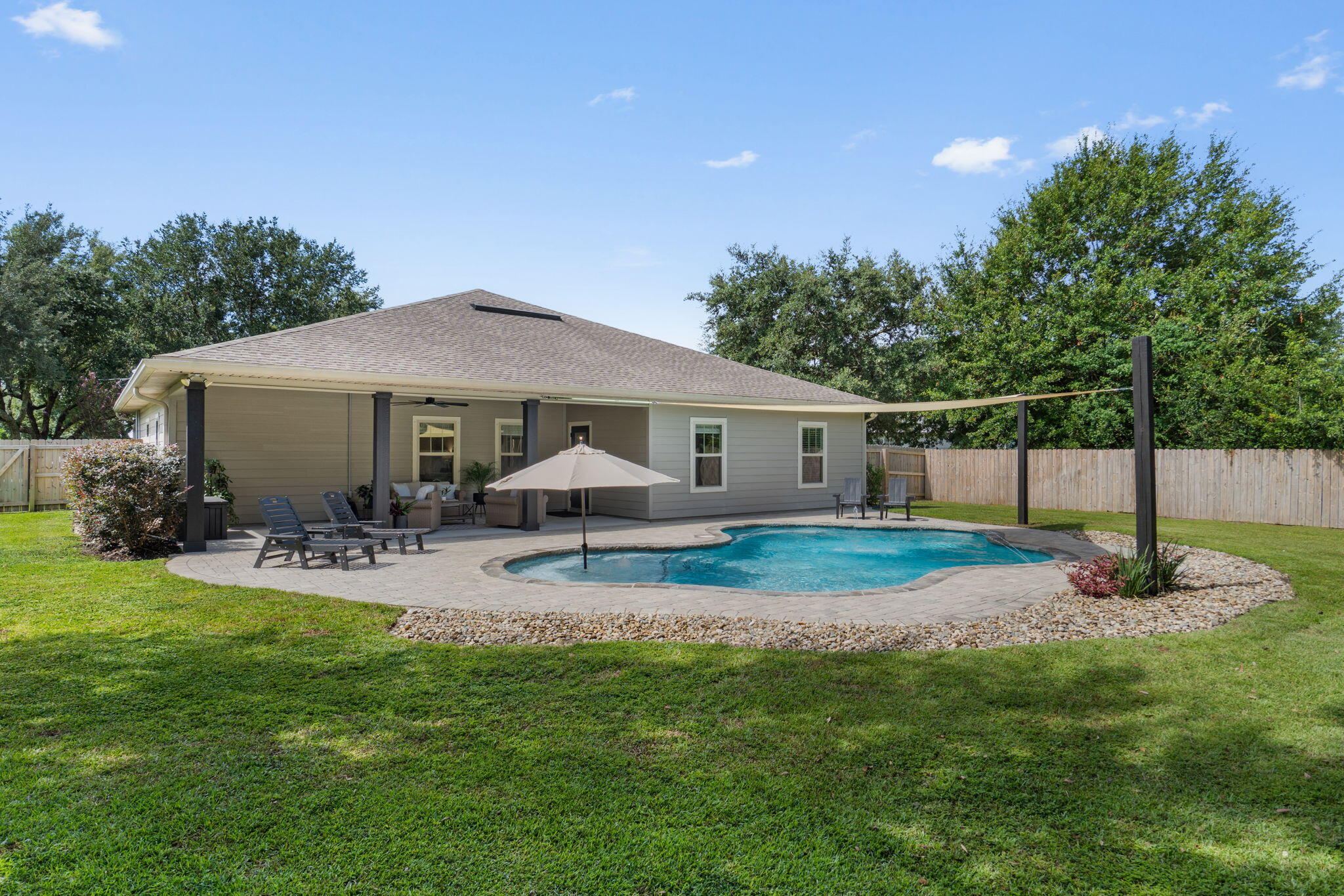 This. Is. THE. ONE.
Stunning, meticulously maintained, and packed with thoughtful upgrades, this 2018 built 4 bedroom Navarre home offers the kind of indoor-outdoor living that makes Florida living so easy to love. Tucked away on a dead-end cul-de-sac in a prime Navarre location and within walking distance to schools, this home pairs a beautifully customized interior with an incredible backyard retreat featuring a gunite saltwater pool, expansive paver decking, firepit, and fully fenced yard (the chickens will even stay if you'd like daily fresh eggs!).

From the moment you step inside, the attention to detail is impossible to miss. The home features LVP flooring throughout, crown molding, wide baseboards, tray ceiling accents, transom windows, custom window framing, and extensive trim work that gives each space a polished, custom feel. Fresh interior paint and upgraded light fixtures and fans throughout in 2026 make the home feel bright, current, and truly move-in ready.

The kitchen is both beautiful and functional with shaker-style cabinetry, granite countertops, stainless steel appliances, tile backsplash, under-cabinet lighting, upgraded hardware and faucets, custom trim detailing on the island, and a range hood. A dedicated pantry outlet allows the microwave to stay conveniently tucked away, keeping countertops clean and uncluttered.

The living area is anchored by a beautiful fireplace and mantle added in 2024, creating a warm focal point for the open living and dining spaces. Custom touches continue throughout the home, including updated door hardware, upgraded fixtures and faucets, hallway trim work, and thoughtfully added details at nearly every turn.

The primary suite is a standout of its own, featuring a tray ceiling, custom box trim added in 2026, and a beautifully renovated primary shower. Both bathrooms have been refreshed with upgraded mirrors, faucets, fixtures, exhaust fans, painted vanities, and updated trim, while two additional bedrooms feature upgraded closet systems for added organization.

Step outside and you'll quickly see why this spacious backyard may become your favorite part of the home. The gunite pool was added in 2019 and later converted to saltwater, with a variable-speed pool pump and cordless robotic pool vacuum making maintenance a breeze. Pavers surround the pool and there's even a separate paver firepit, creating plenty of space for entertaining, grilling, swimming, or relaxing at the end of the day. Mature landscaping, irrigation, a fenced backyard, flood lights, and a shaded chicken coop with its own fenced enclosure add even more functionality to the outdoor space.

And when Florida weather rolls in, this home is ready. A transfer switch and 12,500-watt portable generator provide valuable peace of mind, while gutters, shutters, a storm door, smart locks, doorbell camera, and additional exterior improvements add to the home's long list of thoughtful upgrades.

With its cul-de-sac setting, walkability to schools, resort-style pool, beautifully updated interior, and years of carefully selected improvements, this is so much more than a house that's been maintained - it's a home that's been continually made better.

This is the one you've been waiting for.