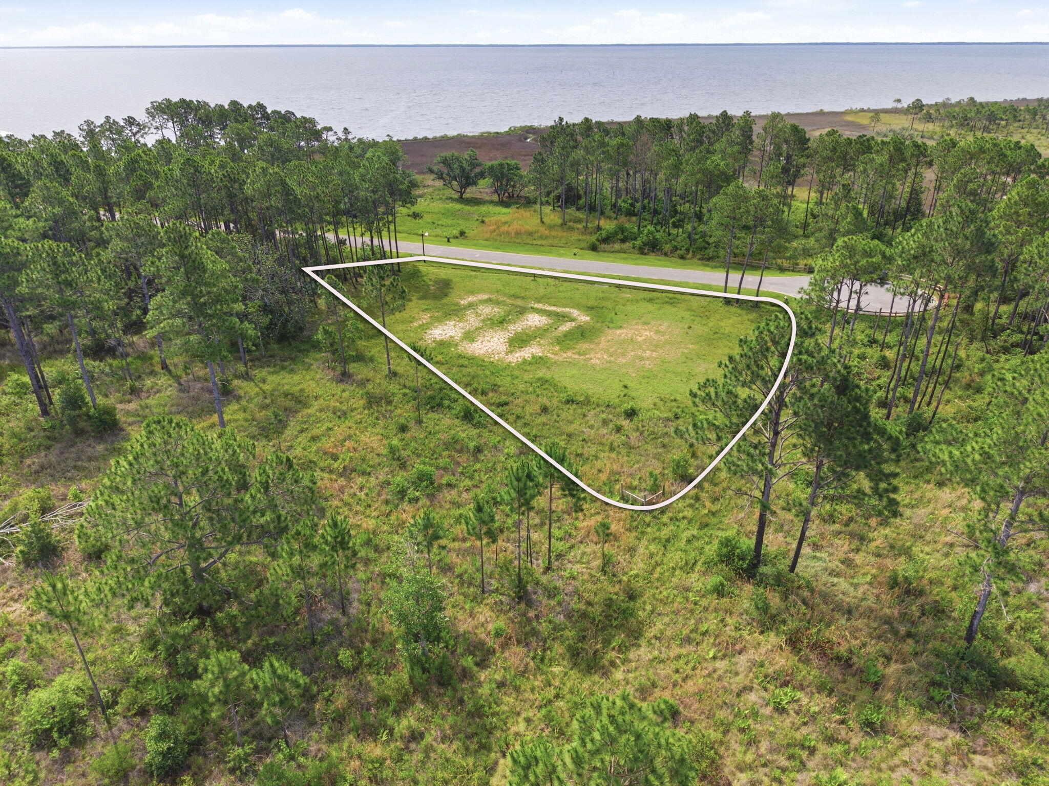 Come build your dream home on this beautiful Blackwater Bay view lot in Milton, FL! The lot is tucked away at the end of a quiet cul-de-sac inside a private gated subdivision. This ready-to-build homesite offers the perfect blend of privacy, convenience, and coastal living. Enjoy peaceful bay views with the added bonus of 109 acres of protected state land bordering the rear and one side of the property, providing a natural backdrop and added privacy with no future neighbors building directly behind and on one side of you. This quaint community features underground utilities and a shared community lake and gazebo for residents to enjoy. The water tap has already been paid for, helping make the building process even easier. Conveniently located just 6 miles from I-10 and only 17 miles from Pensacola Beach, you'll have quick access to shopping, dining, beaches, and everything the Gulf Coast has to offer. Whether you're planning your forever home or a peaceful getaway, this exceptional lot is ready for your vision.