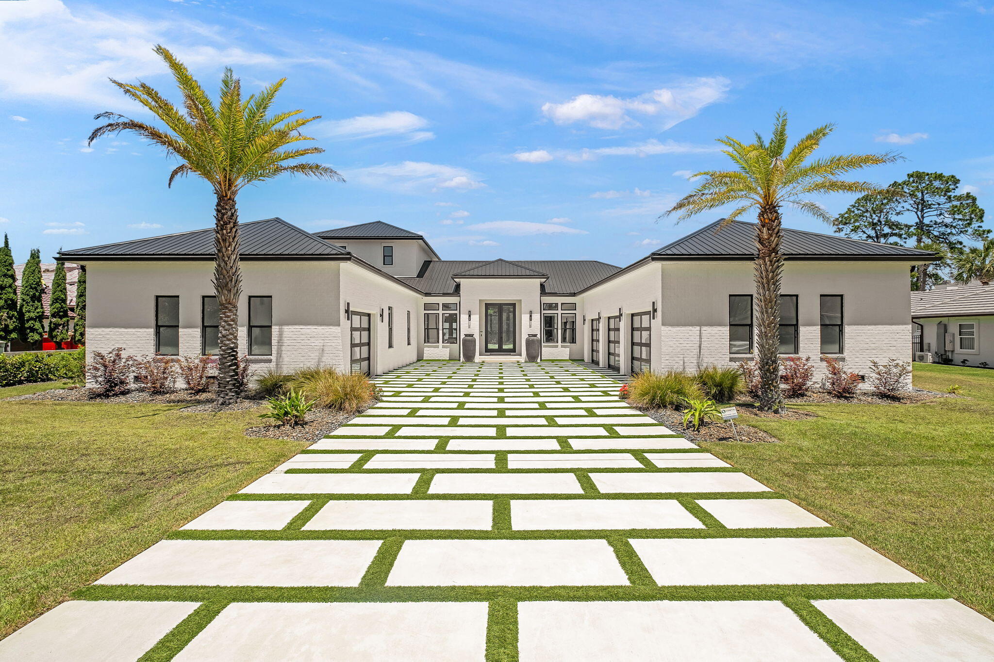 Perfectly positioned on the bay and masterfully constructed by Jared Boswell, this extraordinary coastal modern estate is a showcase of intentional design, elevated craftsmanship, and effortless luxury living. From the moment you arrive, the striking custom modern driveway, dramatic architecture, and symmetrical approach framed by towering palms create an unforgettable first impression. Inside, walls of glass capture breathtaking panoramic bay views while warm Cypress wood accents soften the home's clean contemporary lines, creating a elevated yet inviting atmosphere throughout.

Designed with both grand scale entertaining and everyday comfort in mind, the residence features expansive open living spaces, upgraded lacquer cabinetry, oversized closets throughout, and a thoughtfully designed walk in pantry with exceptional storage. The chef's kitchen flows seamlessly into the main living and dining areas, all perfectly positioned to maximize the sweeping waterfront backdrop. A stunning upstairs recreation room offers an additional entertaining space complete with wet bar, beverage refrigerator, ice maker, and incredible views from the second level.

The luxurious primary suite is a true retreat, featuring spa inspired finishes including a steam shower with dual rain heads and handheld fixtures, a TOTO heated toilet, and beautifully curated designer details. Every guest bedroom offers the privacy and convenience of its own en suite bath. 

Additional specialty spaces include a custom wine cellar, built-in pet wash station, separate upstairs storage room with garage access, and heated/cooled garages with beautifully crafted custom garage doors.

This smart home is extensively equipped with premium technology and infrastructure including Control4 whole-home automation, integrated security system, Lutron lighting, Sonos audio, underwater speaker system wiring, exterior Jellyfish lighting, invisible fence system, whole-house generator, and a whole-home water filtration system. 

The outdoor living is equally spectacular. The fully turfed backyard was designed for low-maintenance luxury and features a private putting green, a stunning negative-edge saltwater pool and spa, expansive covered entertaining areas, outdoor kitchen with beverage center, SunBrite outdoor TV, outdoor shower, and dedicated pool bath. The sweeping bay views create an incredible backdrop for waterfront living, offering the perfect setting for both peaceful mornings and unforgettable evenings. Extending from the property is a private dock complete with both boat lift and two jet ski lifts, offering immediate access to life on the water.

Blending refined coastal elegance with state of the art amenities, this one of a kind waterfront residence delivers an extraordinary lifestyle experience from every angle.