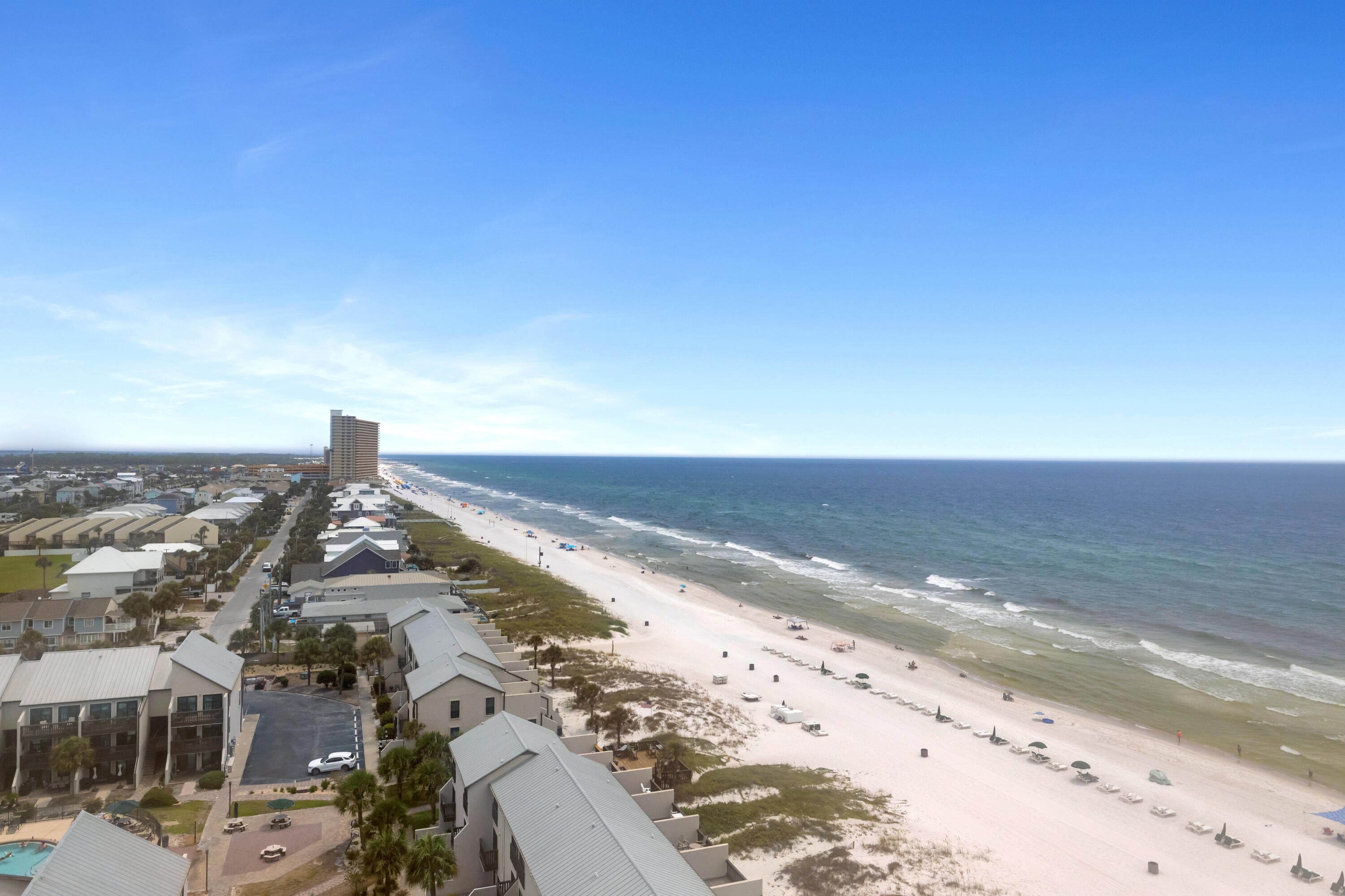 COOLER-SIDE LOCATION. SUNRISE COASTLINE VIEWS. CORNER-BALCONY LIVING. Regency Towers 1323 is a three-bedroom, two-bath beachfront condominium positioned on the east corner of the building in Panama City Beach, Florida. The corner balcony provides unobstructed east-facing views along the Panama City Beach coastline, additional lagoon and bay views, and a front-row perspective for sunrise. Tile flooring extends across the balcony, while wood-grain-look tile runs consistently throughout the interior.
All-new sliding glass doors and windows frame the surrounding views. Interior details include updated light fixtures, wainscoting accents in the hallways and bathrooms, updated bathroom vanities, and comfort-height toilets. The primary bedroom suite is furnished with a king-size bed. The second bedroom includes full-over-queen bunk beds, and the third bedroom is furnished with a full-size bed.
The kitchen features stainless steel appliances, and the unit includes a front-loading stackable washer and dryer. HVAC was replaced in 2017, and the water heater was replaced in 2021.
Regency Towers is a gated beachfront condominium community in the South Lagoon area of Panama City Beach, near St. Andrews State Park, area attractions, and dining options including Schooners, Patches Pub, and Captain Jack's. Community amenities include 24-hour security, on-site parking, two beachfront pools with one seasonally heated, a wading pool, indoor hot tub, owners' lounge, fitness center, game room,  picnic and grilling area, private beach access by boardwalk, and The Sandbar, a recently remodeled on-site dining option currently open daily from 11 AM to 6 PM.
HOA dues are currently $2,546.30 per quarter and include water, sewer, trash service, pest control, and access to community amenities. Pets are not permitted under current association rules. Assistance animals are governed by applicable law and association procedures. All information is deemed reliable but not guaranteed; buyer to verify if important.