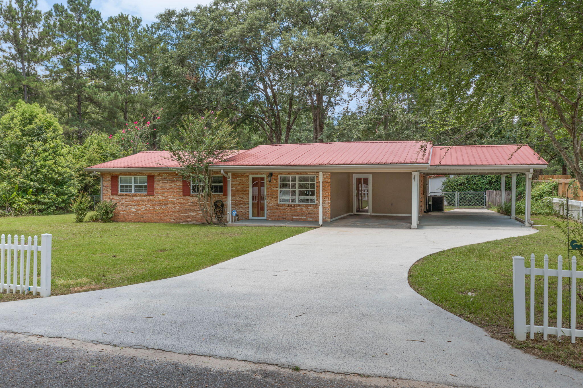 CURRENTLY UNDER CONTRACT, SELLER WILL CONSIDER BACKUP OFFERS. Beautifully updated brick home tucked away at the end of a quiet street in the heart of Bonifay. Recent improvements include quartz countertops, fresh interior paint, updated light fixtures, and all new flooring throughout the home. The kitchen features stainless steel appliances, a breakfast bar, and ample cabinet space. The versatile floor plan offers multiple living areas, including a spacious sunroom, two bonus rooms, and a unique primary suite featuring two walk-in closets and an additional connected space that could serve as a nursery, home office, sitting room, dressing room, fitness area, or private retreat. Outside, you'll find a metal roof, covered front porch, open patio, two-car carport, fenced backyard, and two large powered outbuildings. One offers endless possibilities as a hobby space, craft room, she shed, man cave, workshop, or additional storage and includes an attached covered lean-to. The second, larger building features a spacious workshop/storage area with shelving already in place, along with a generous covered area for equipment, projects, or additional storage. Conveniently located near shopping, dining, schools, and everyday amenities, this property offers modern updates, versatile living space, and exceptional storage both inside and out. Additional Features:

* Oversized bonus/flex room with closet
* Double-pane vinyl windows
* Updated electrical service with breaker panel
* Full-size washer and dryer included
* Laundry room with built-in cabinetry
* Gas range
