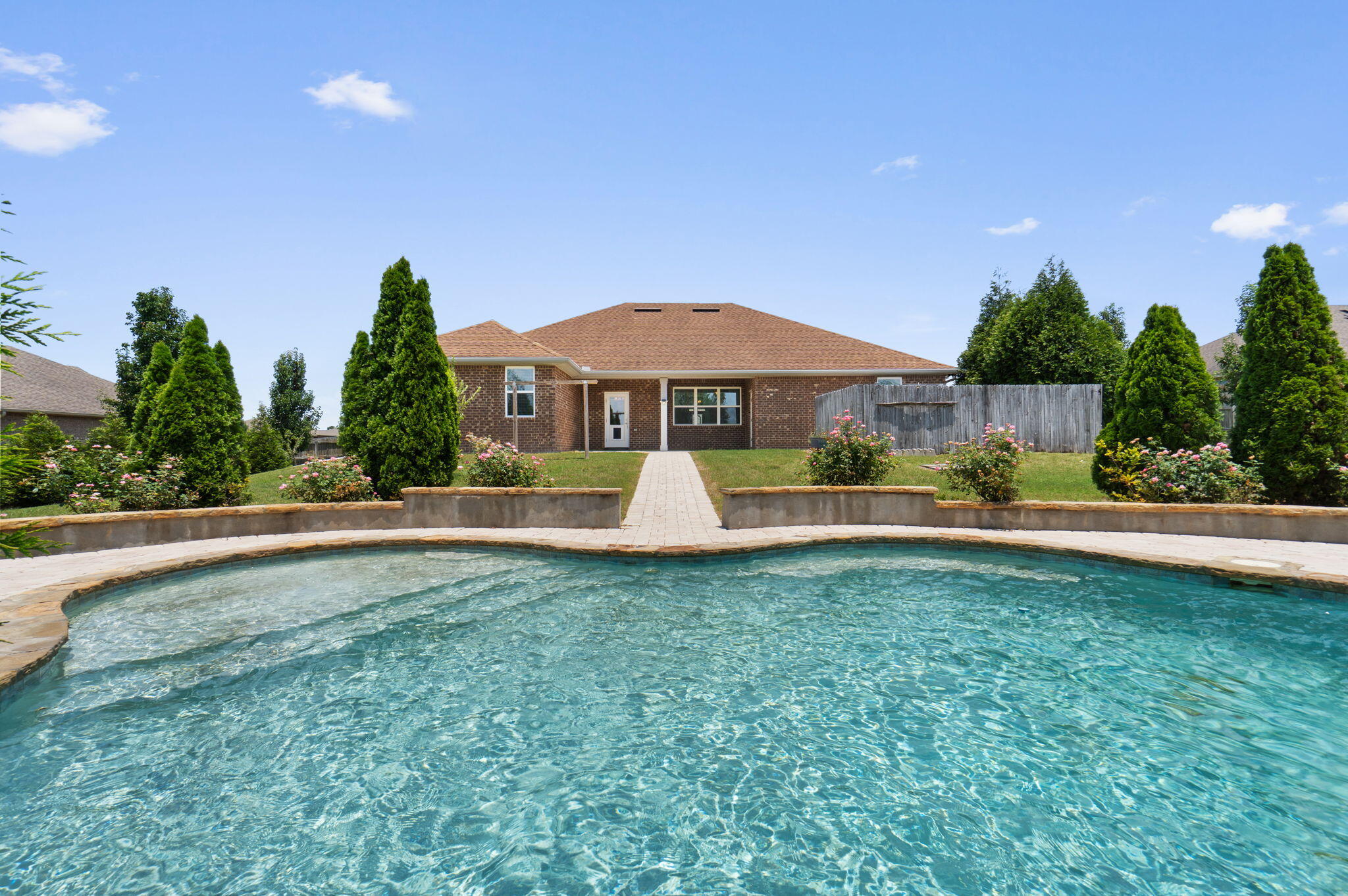 Resort-style living starts here! Built in 2017, this beautifully maintained all-brick home POOL offers 4 bedrooms, 3 bathrooms, a dedicated office, and an additional flex room on a beautifully landscaped 0.56-acre lot in Carnegie Hills. Step into your own private backyard oasis featuring a sparkling inground gunite pool surrounded by mature privacy trees, a separate fenced hot tub retreat, a fully fenced backyard, and a large storage building with covered storage space. There's still plenty of green space for pets, play, or gardening, making this backyard ideal for both entertaining and everyday living!

Inside, the open-concept floor plan features soaring tray ceilings, abundant natural light, and spacious living areas. The kitchen is designed for gathering with quartz countertops, stainless steel appliances, white cabinetry, a large center island with bar seating, recessed lighting, and a walk-in pantry. The oversized owner's suite offers a spacious sitting area and an ensuite bath with dual quartz vanities, a soaking tub, separate walk-in shower, private water closet, and walk-in closet. Three additional bedrooms, two full guest baths, plus the office and flex room provide exceptional versatility. Paver walkways lead from the covered patio to the pool, creating a seamless outdoor living space. Move-in ready and designed for comfortable living, this home truly has it all!
