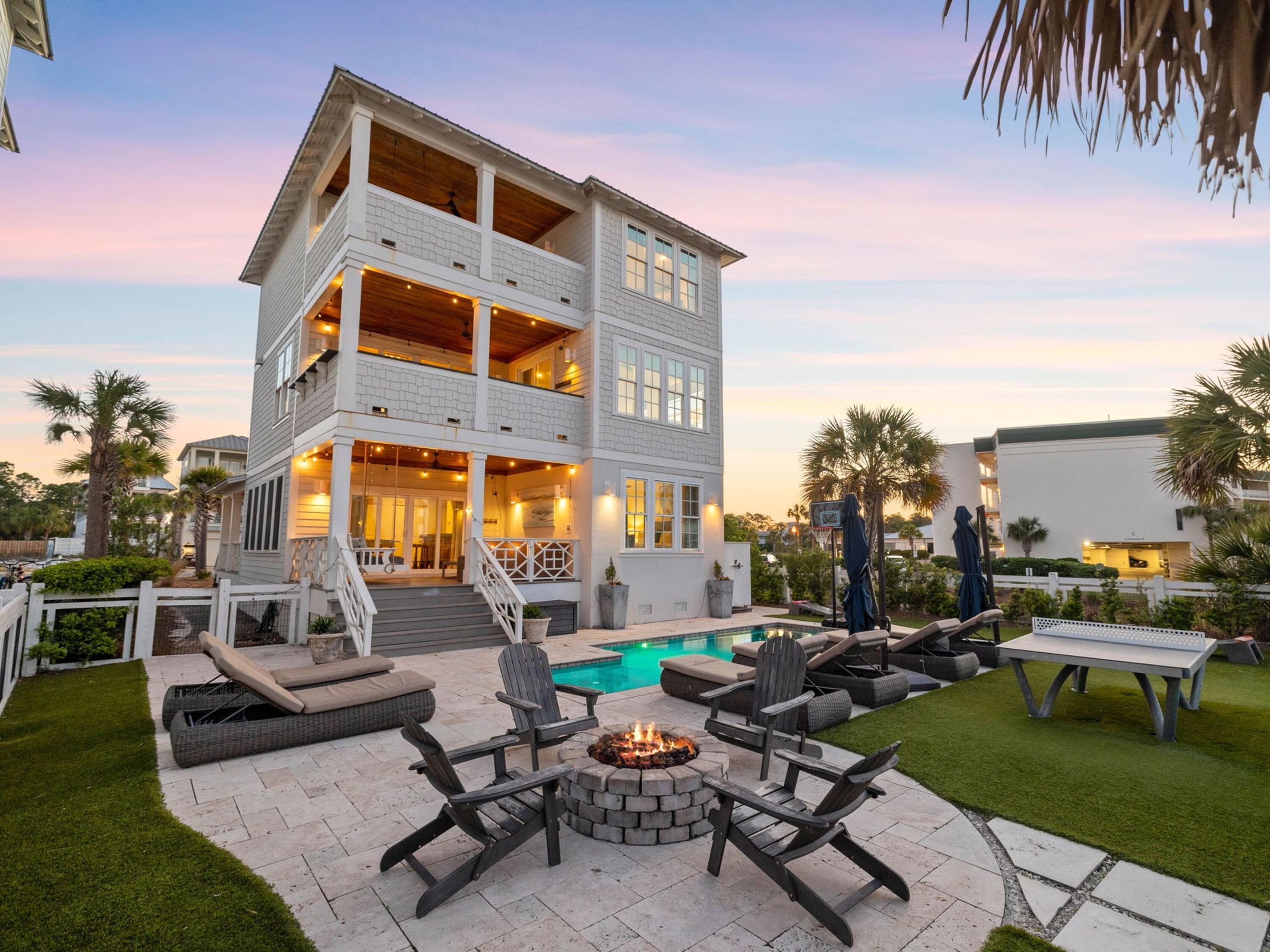 Nestled on a serene cul-de-sac just a block from the Gulf of Mexico, this expansive three-story beach house perfectly captures the sought-after 30A lifestyle. With sweeping views of a private heated saltwater pool from multiple covered balconies, every moment feels like a retreat. The first floor invites relaxation with a guest bedroom, game room with TV and bar, and a furnished outdoor lounge overlooking the pool and private yard. The second floor is designed for entertaining, featuring hardwood floors, shiplap ceilings, and a chef's kitchen with granite countertops, custom cabinetry, stainless appliances, and a long bar for cocktails or casual bites. Doors open to a deep porch for alfresco dining, complemented by an outdoor kitchen with grill and refrigerator. Two additional guest bedrooms offer comfort and privacy.
The top floor hosts a luxurious master suite with panoramic gulf views, spa-style bath with oval tub and twin marble vanities, a second sitting area with wet bar/coffee station, and a bunk room for guests. Outside, lush turf, paved patios, and a fire pit invite days of poolside leisure, ping pong, cornhole, and evening s'mores.
Ideal for full-time coastal living, this home also offers significant rental potential, generating over $264,000 in rental income in 2025. Located in Seagrove's desirable Eastern Lake area, you're minutes from boutiques, cafés, seafood restaurants, Deer Lake State Park, and the Timpoochee Trail.