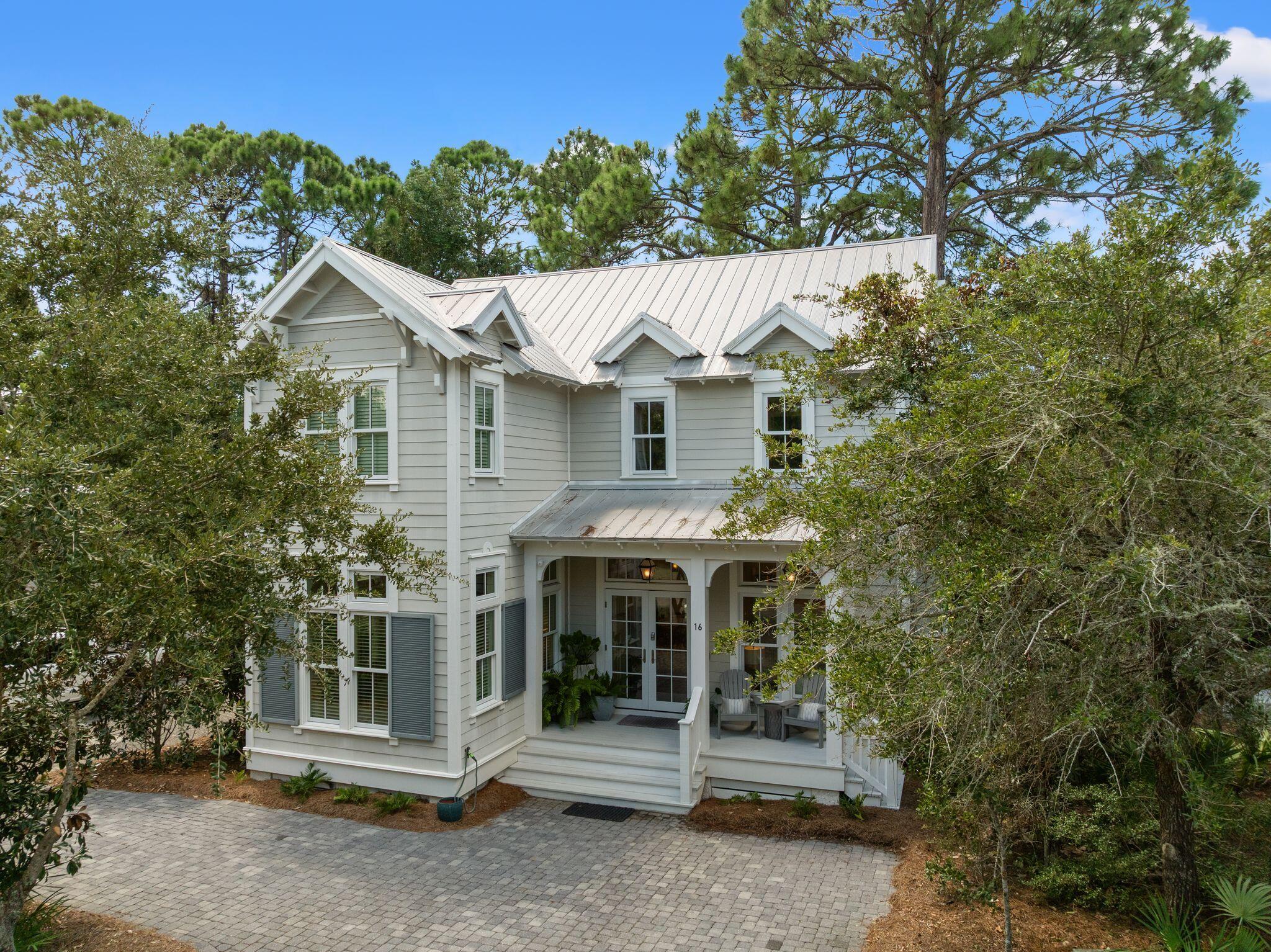 Nestled within the gated community of The Hammocks of Seagrove, 16 Spanish Moss Lane is a beautifully inviting 4-bedroom, 3.5-bath coastal retreat offering an exceptional location less than half a mile from the sugar-white sands and turquoise waters of the Gulf.

Designed for relaxed coastal living and effortless entertaining, the home welcomes you with a light-filled, open-concept living, dining, and kitchen area. Oversized windows bring in abundant natural light, while the vaulted ceiling adds volume and creates an airy, expansive feel. At the heart of the home, the kitchen features quartz countertops, stainless steel appliances, generous cabinetry, and a large center island ideal for gathering with family and friends. The first-floor primary suite is a peaceful retreat, surrounded by windows that fill the room with natural light and enhance its spacious feel. The en suite bath is complete with dual vanities, a soaking tub, and separate shower.

Upstairs, an open overlook to the living area maintains the home's bright and connected feel. Three additional bedrooms include a charming custom bunk room, along with two full baths, providing plenty of space for family and guests.

Just outside, the shaded back patio creates an inviting extension of the living space and is perfect for grilling, gathering around a fire pit, or unwinding after a day at the beach.

One of the home's greatest highlights is its location in the heart of Seagrove, where some of 30A's most sought-after destinations are just moments away. Enjoy easy access to the beach along with the renowned dining, boutiques, coastal dune lakes, and scenic bike paths of Seagrove. Neighboring WaterColor and iconic Seaside are also just minutes away, offering even more dining, shopping, entertainment, and quintessential 30A experiences.

The Hammocks is a private, gated community with two community pools, offering a peaceful residential setting while keeping you close to everything that makes this stretch of 30A so desirable. Whether envisioned as a primary residence, second home, or vacation rental, 16 Spanish Moss Lane offers an exceptional opportunity to enjoy the best of the 30A lifestyle from a charming coastal cottage in the heart of it all.