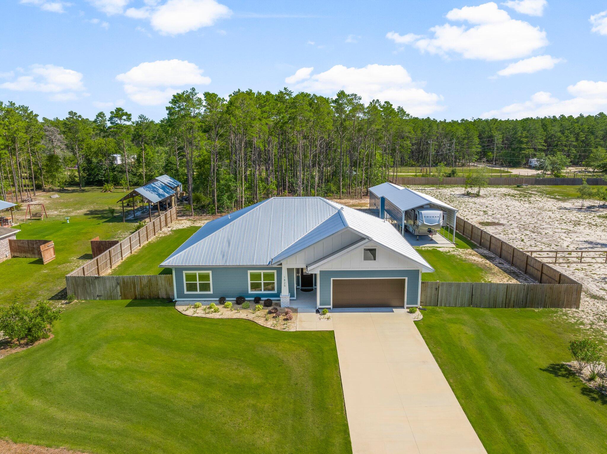 This fantastic home, originally built as the Scholarship Home and showcased in the 2023 Bay County Parade of Homes, offers exceptional quality, thoughtful upgrades, and the peace and quiet of life in the sought-after White Western area. Set on nearly an acre, this former model home is ideal for anyone looking to enjoy a bit more space, privacy, and a slower pace.

Living outside the city of Lynn Haven means fewer restrictions, no HOA fees, and the kind of tranquility you cannot find in more densely populated neighborhoods. The home is designed with efficiency and long-term savings in mind, featuring foam insulation throughout (even over the garage) along with a private well and septic system, eliminating monthly water and sewer bills. Homeowners insurance is currently under $200 per month with a quality State Farm policy, and the property is located in flood zone X, so flood insurance is not required.

Inside, you'll find soft-close cabinetry, a stunning leathered granite island paired beautifully with sleek quartz countertops throughout the kitchen, upgraded lighting, energy-efficient windows, and heated mirrors in the primary bath. The layout is functional and inviting, with quality finishes and modern comforts throughout.

Outside, the property has been thoughtfully enhanced with over $75,000 in improvements. There is a generator plug already in place, so you can easily hook up a generator if the power goes out. The sellers cleared trees, added a fenced area for pets, constructed a spacious 23 x 31.5 screened-in patio with a concrete floor for relaxing and enjoying nature, and built both an 18 x 30 workshop with gutters, as well as a 14-foot tall, 18 x 35 pole barn with 50-amp service plug for a boat or RV. The sprinkler system is tied to the well, keeping the lush Bermuda grass green without added utility costs.

This is a rare opportunity to own a well-appointed, energy-efficient home with acreage, freedom, and upgrades already in place. If you've been waiting for the perfect blend of space, comfort, and quiet country living, this is the one. Don't miss your chance to make it yours.