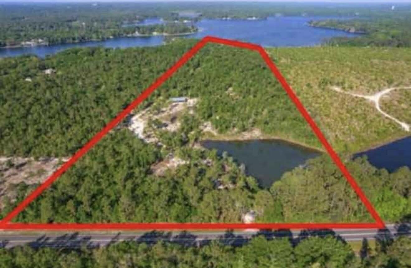 Over 31 acres with approximately 350 feet of frontage on Juniper Lake, offering a rare opportunity for expansive waterfront living in DeFuniak Springs. The property features lake frontage along Hwy 83 North and is located just 35 miles from the white-sand beaches and emerald waters of the Gulf.

Situated approximately 250 feet above sea level, this property is not in a flood zone and is positioned inland from the hurricane-prone coastline. A palm-lined entrance leads to a mature oak hammock and opens to elevated, panoramic lake views with stunning sunset vistas.

Ideal for fishing, building a private estate, or keeping for a long-term investment. A 40' x 60' newer pole barn adds immediate utility. A rare combination of lakefront acreage, elevation, and proximity to the beach!