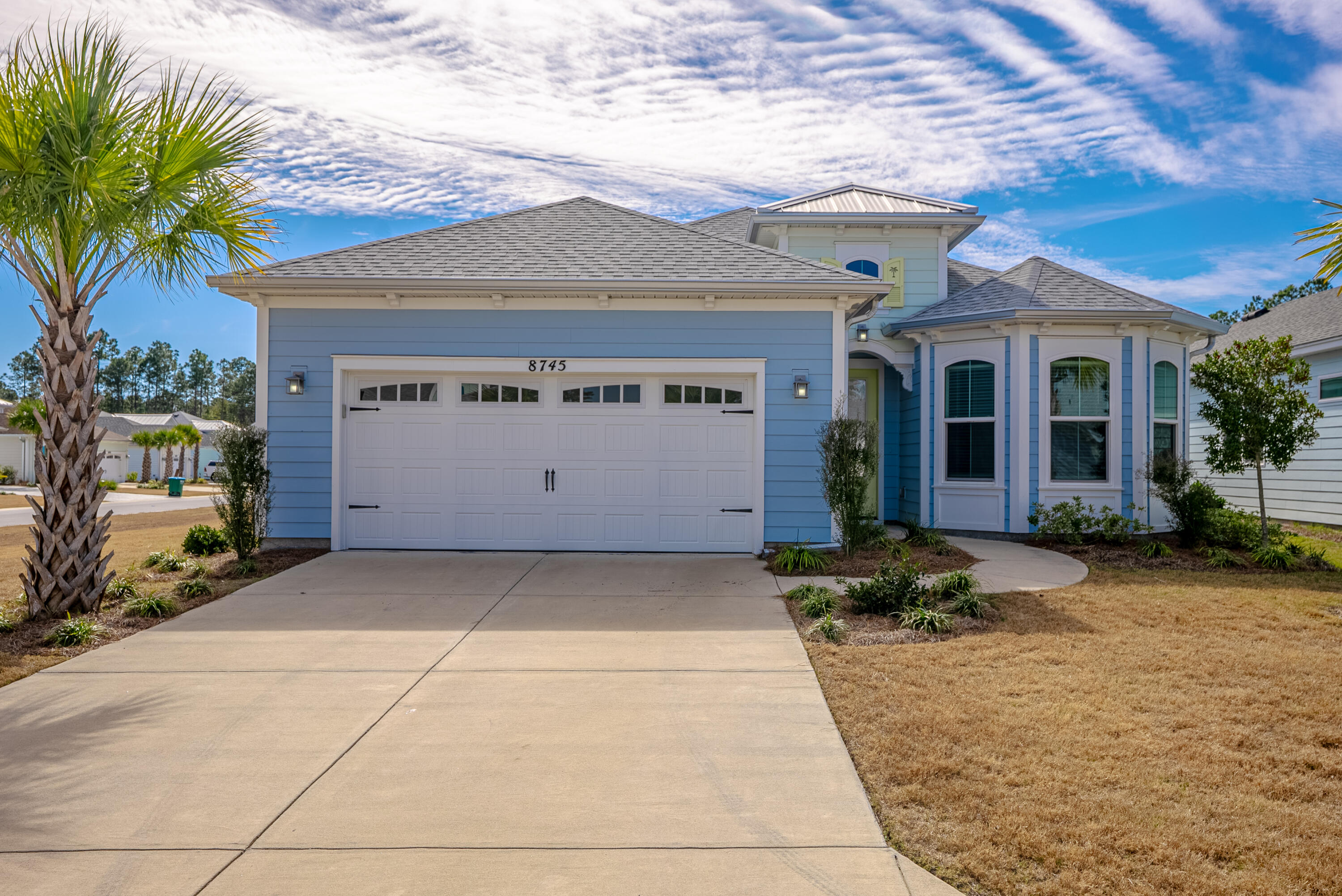 INCREDBLE OPPORTUNITY! TENS OF THOUSANDS IN UPGRADES:  Whole house generator, window wall, custom blinds/curtains, gas stove, wall oven, wine cooler, pull out garbage can cabinet, 3 way dressing mirror and more!  Experience easy resort-style living in Margaritaville with this beautifully maintained Breeze Bay corner-lot home. Featuring 3 bedrooms and 3 baths, it offers stylish vinyl plank flooring throughout. The chef's kitchen boasts quartz countertops, tile backsplash, wine cooler, gas cooktop, wall oven, microwave, and a large island, opening to the dining and great room. Sliders lead to a screened lanai with serene pond views. The primary suite includes his and her closets, dual quartz vanities and a gorgeous shower.  As a plus, there is  a private guest suite and a full bath just outside the 3rd bedroom.  Extras include appliances, custom blinds, epoxy garage and lanai, storage, and a whole-house generator. Enjoy 55+ amenities, lawn care, and nearby shopping and dining