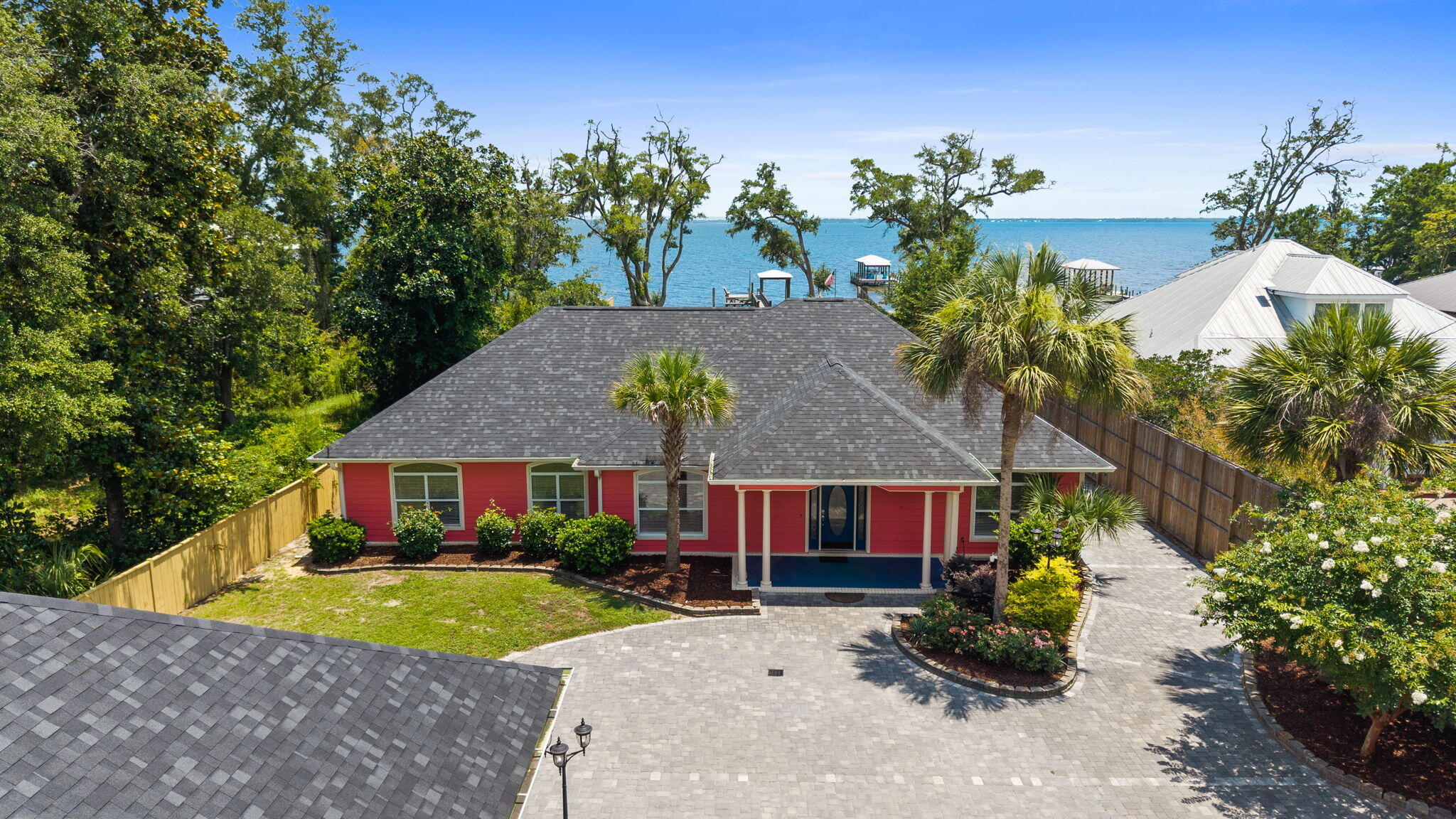 Waterfront multigenerational dream home on half an acre, all on one level and fully fenced for privacy, security, and fun. This rare property offers two separate homes, a covered pool, private dock, and tons of parking--perfect for a large family, multi-gen living, or a primary residence with incredible Airbnb/short-term rental potential.

The main home is a spacious 3 bedroom, 2 bathroom layout with easy, single-level living, water views and includes a true mother-in-law suite with its own full kitchen, bathroom, and private access that leads directly out to the covered pool area--ideal for extended family, guests, or income-producing space. The second home is also a 3 bedroom, 2 bathroom layout. Multiple living areas, split bedrooms, and separate entrances give everyone room to spread out while still feeling connected.

Step outside to your own private resort: a screened/covered pool just steps from both homes, a private dock for boating, fishing, or paddleboarding, and a fully fenced yard with privacy fence and gated entry. The oversized lot (approximately half an acre) offers room for kids, pets, toys, and gatherings, with ample driveway space and parking for cars, RV, or boat. This is an entertainer's paradise and a true lifestyle property--waterfront living, no stairs, multiple kitchens, and flexible spaces that can adapt as your needs change.