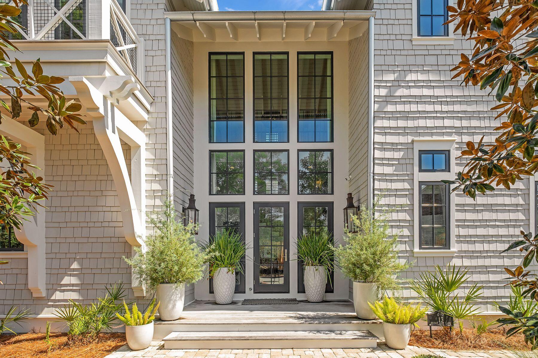 Set within the gated enclave of Draper Lake Coastal Village on Scenic Highway 30A, 13 Bridge Cove Lane offers a rare combination of architectural pedigree and livable luxury. Designed by acclaimed architect Geoff Chick and built by Chris Clark, this 3,521-square-foot residence delivers four bedrooms and four-and-a-half baths across a thoughtfully scaled floor plan, ideal as a full-time coastal residence or an effortless second home along 30A.

A two-story foyer with floor-to-ceiling glass welcomes you with abundant natural light, while hardwood floors guide you into an open living area defined by 12-foot coffered ceilings with pecky cypress insets. The combined kitchen, dining, and living space makes an immediate impression, anchored by a marble-topped island and a professional-grade appliance package, with a fireplace adding warmth and balance to the main living area.

The main level also includes a first-floor guest suite, powder bath, laundry, and a two-car garage. Upstairs, the primary suite features vaulted ceilings, a soaking tub, walk-in shower, double vanity, and generous closet space. A second guest suite, additional living area, and screened porch offer flexible space for relaxing or working from home, with laundry conveniently located on both floors.

A detached carriage house with private exterior access adds a self-contained kitchenette and ensuite bath, perfect as a guest suite, home gym, or private office. Outside, a private heated pool and covered porches create seamless indoor-outdoor living, all within a community that does not allow short-term rentals, preserving its quiet, residential character.

Draper Lake Coastal Village is a gated, dune-lake community on 30A inspired by the great communities of the Adirondacks, designed by the Planners Duany Plater-Zyberk & Company that also designed Seaside, Rosemary Beach, and Alys Beach. Residents enjoy pools, boathouses, trails, and a private beach cabana, just moments from 30A's dining, shopping, and bike path.

A rare opportunity to own a custom-built, architect-designed home in one of 30A's most distinctive gated communities.