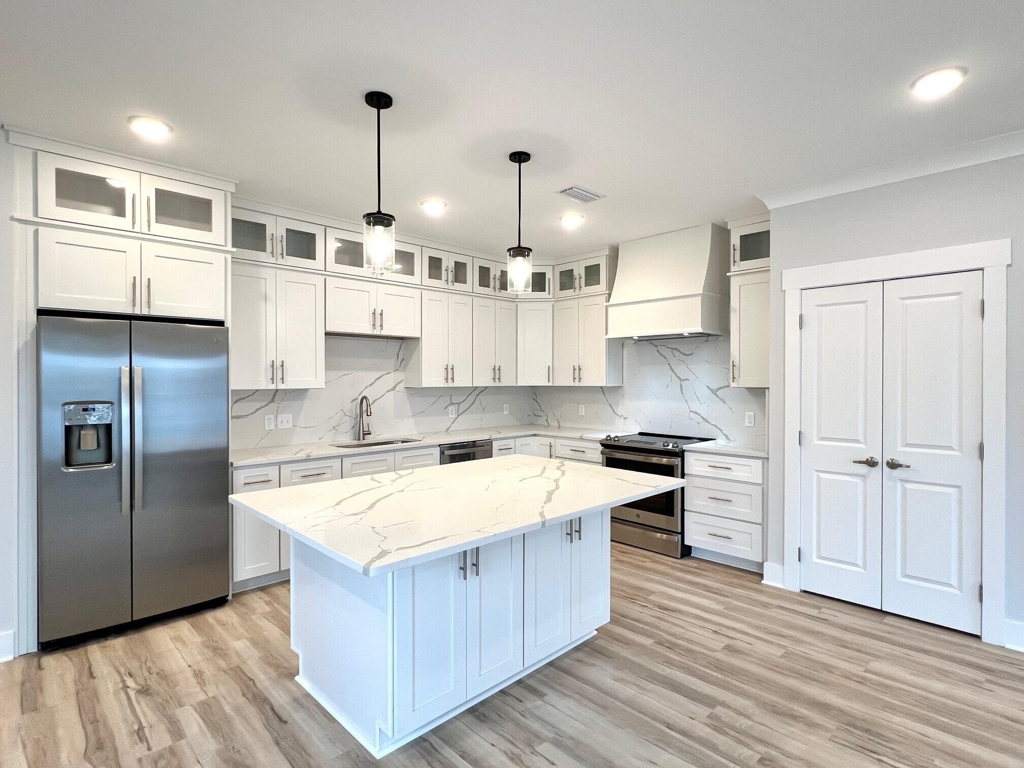 Gorgeous new 3BR/2.5BA townhouse at the Beach Lofts community nestled within the heart of Destin. Unit 5 is an end unit boasting just under 1,800 sq. ft. with exquisite details throughout. Upon entry you'll quickly notice how spacious the townhouse is with the raised ceilings & open floor concept. The luxurious kitchen features beautiful Quartz countertops & backsplash, timeless shaker cabinets, stainless steel appliances, and ample storage space with a large pantry & island. Wood look LVP flooring extends throughout the townhouse with beautiful decorative tile floors in the full bathrooms. The double doors off the living area lead to an expansive covered patio equipped with an outdoor shower and setup for a TV if desired. The convenient half bath on the first floor is perfect for guests.