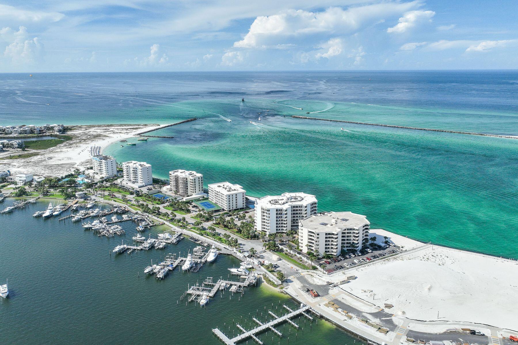 Back on market at no fault of Sellers. SIRS complete and all assessments paid. Perched on the sixth floor at the very tip of Holiday Isle, this gracious residence offers panoramic views that sweep from the Destin Harbor to the sparkling gulf waters of the East Pass. Walls of floor-to-ceiling glass, a gas fireplace and a generous balcony that spans the full width of the unit invite both sunlight and sea breezes into nearly every corner, creating a serene waterfront sanctuary. The spacious layout unfolds with ease, offering a large living and dining area that is seamlessly connected to a well-appointed kitchen, complete with granite countertops, stainless steel appliances, a generous bar, and a dedicated wine bar, all designed for effortless entertaining. Two private master suites, each with its own ensuite bath, provide luxurious accommodations for owners and guests alike, while a third bedroom and full bath offer additional flexibility. Resort-style amenities elevate everyday living, featuring an exclusive owners-only seasonally heated pool, hot tub, fitness center with sauna, a club room for events, as well as a private stretch of white-sand beach. A covered garage space right by the elevator entrance a dedicated storage room room add convenience. A private marina just across the street offers deep-water boat slips for sale, for boaters who want to enjoy Destin's famed waterways. No boat, no worries, as you can call the boat taxi to pick you up at the East Pass Marina dock for quick trip across the water to award winning, boat-to-table seafood restaurants and night life on the harbor. East Pass Towers II is a secure, gated building renowned for its quiet, residential atmosphere with a 3-month minimum rental period. Featuring thoughtful updates, the condo association has proactively completed all needed maintenance and improvements and all assessments have been paid by the seller. From fireworks and air shows on summer nights to tranquil mornings watching boats or dolphins glide by, this is waterfront living at its finest. Destin Executive Airport is just 2.3 miles away for all the pilots wanting to escape the beach or if you prefer charter services. Don't miss the new and improved Norriego Point Beach Access and Park which include ADA accessible restrooms, showers, drinking fountains, environmental educational signage, bike racks, boardwalk, dune crossovers, and vehicle parking.