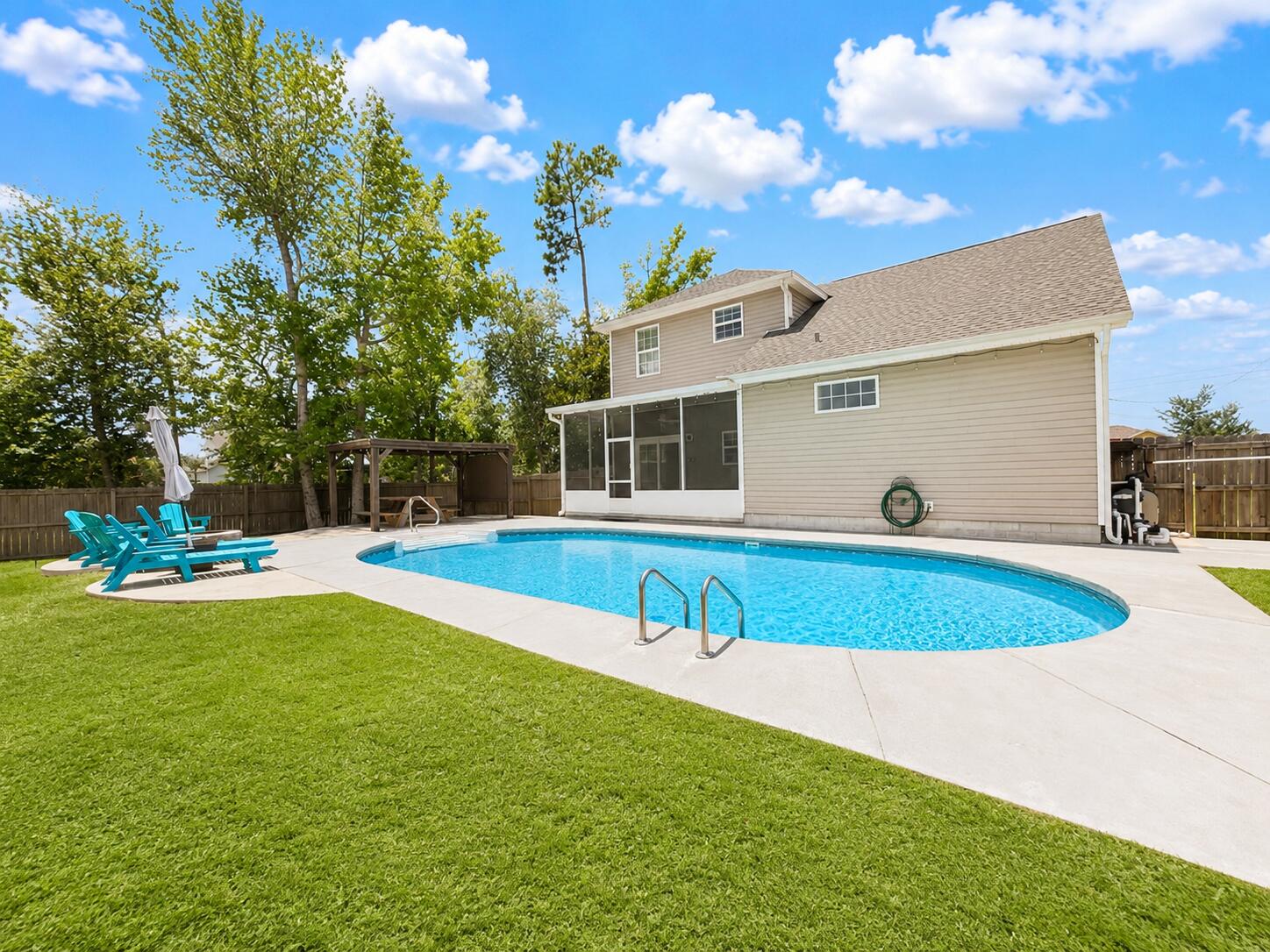 Welcome to a home that's built for making memories. Perfectly positioned on a spacious corner lot in one of Lynn Haven's most desirable neighborhoods, this beautifully maintained 5-bedroom, 2.5-bath residence offers the ideal combination of space, style, and outdoor living. Step through the front door into an expansive open-concept floor plan highlighted by 10-foot ceilings, abundant natural light, and rich wood flooring throughout the main living areas. The oversized great room flows seamlessly into the dining area and well-appointed kitchen, featuring solid-surface countertops, custom wood cabinetry, stainless steel appliances, generous prep space, and a breakfast bar, perfect for entertaining or everyday living. The main level primary suite provides a private retreat complete with a spacious walk-in closet and an ensuite bath featuring a relaxing garden tub, separate shower. A conveniently located downstairs laundry room adds everyday functionality. Upstairs, you'll find four additional bedrooms, including an oversized flex room that can easily serve as a media room, game room, home office, gym, or fifth bedroom, offering endless possibilities for today's lifestyle. The backyard is where this home truly shines. Step outside to your screened-in lanai overlooking a sparkling saltwater pool, then continue into the fully fenced backyard featuring a custom pergola, fire pit gathering area, children's playset, storage building, and plenty of green space for  pets, games, and entertaining. Whether you're hosting summer pool parties, enjoying family cookouts, or relaxing under the stars, this backyard was designed to be enjoyed year round. Homes offering this combination of five bedrooms, a saltwater pool, multiple outdoor entertaining spaces, and a prime Lynn Haven location are exceptionally rare. Schedule your private showing today and experience everything this incredible home has to offer.