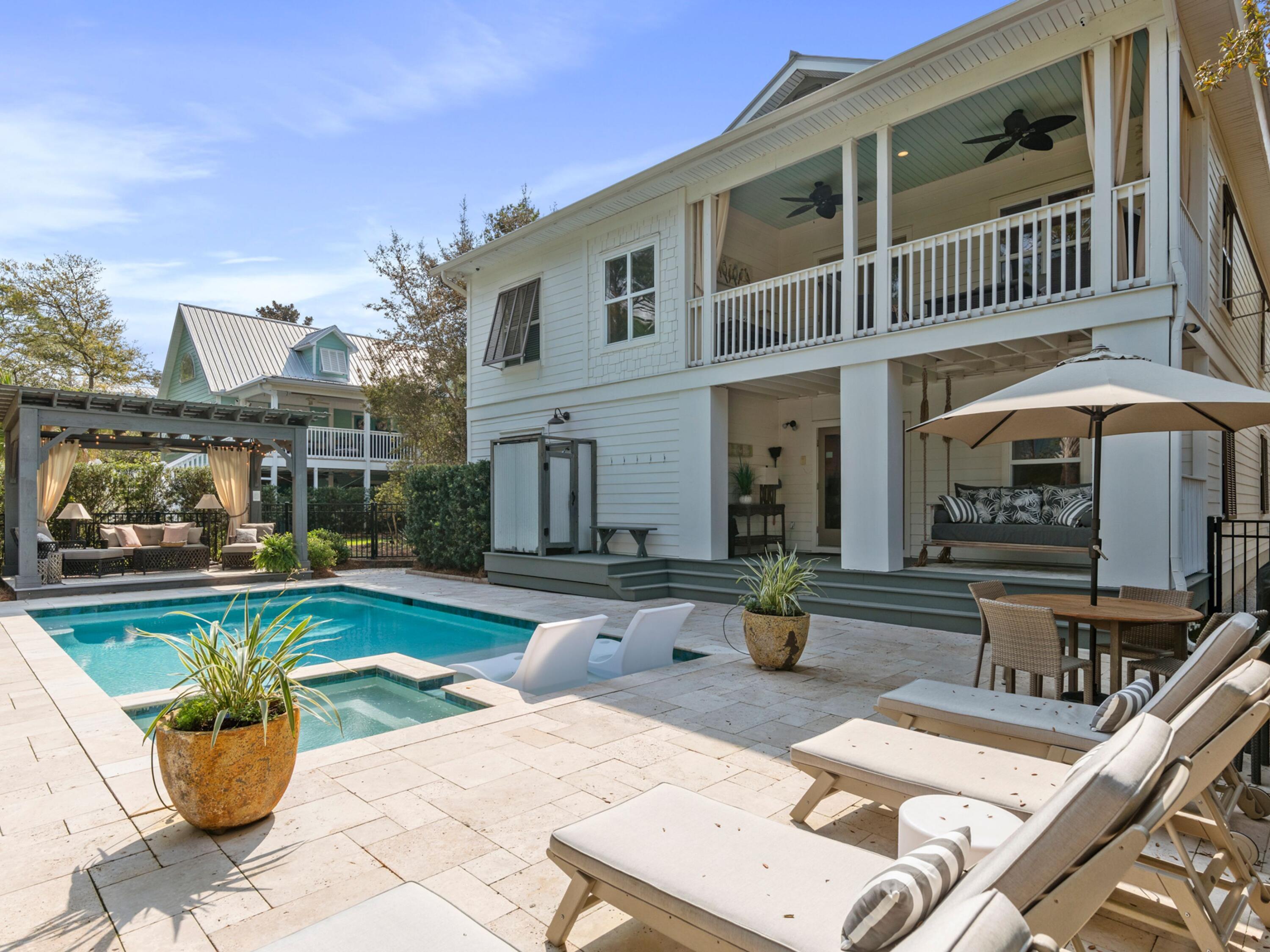 There's a reason homes like this tend to linger in memory. Featured in NICHE's signature series, From The Porch, in 2021, this canal front residence captures the quiet cadence of life along Eastern Lake, where mornings begin on the dock, afternoons drift between the pool and shaded gazebo and evenings stretch easily toward the nearby beach.

Set within a friendly neighborhood just a short stroll or bike ride from two public beach access points, the home offers a rare pairing of lakefront living and coastal convenience. A private newly built dock invites paddleboards, kayaks and early casts, while the heated pool and spillover spa create a backyard designed for long, unhurried days. The curtained gazebo, outdoor shower and generous entertaining areas complete a setting that feels both relaxed and considered.

Inside, the layout is designed for gathering without sacrificing space or privacy. The owners elevator access connects the two levels, where expansive living areas unfold on each floor. The first level includes two bedrooms, two bathrooms, a bunk room that accommodates five, and a secondary living area with a kitchenette, all opening directly onto the covered porch and pool deck. Thoughtful storage throughout, including two single garages built to house watercraft, beach gear and a golf cart, or a car if you wish, adds a practical layer to the home's design.

Upstairs, hardwood floors carry through a bright, open-concept living and dining space anchored by a generously scaled kitchen. Outfitted with a GE Monogram range complete with grill and griddle, a commercial-grade ice maker and extensive cabinetry topped with Quartz, the kitchen is built for both everyday use and larger gatherings. Three additional bedrooms are positioned on this level, while the balcony frames tranquil views across the pool and palms toward Eastern Lake.

Professionally decorated and meticulously maintained, the home is offered fully furnished with appliances and televisions included. Recent updates, such as two new A/C units and Rinnai tankless water heaters, enhance comfort and efficiency. Whether envisioned as a second home or a high-performing vacation rental, this property delivers a compelling combination of lifestyle and versatility, all within easy reach of local favorites, nearby dining and the ever-changing beauty of the lake and gulf just beyond.