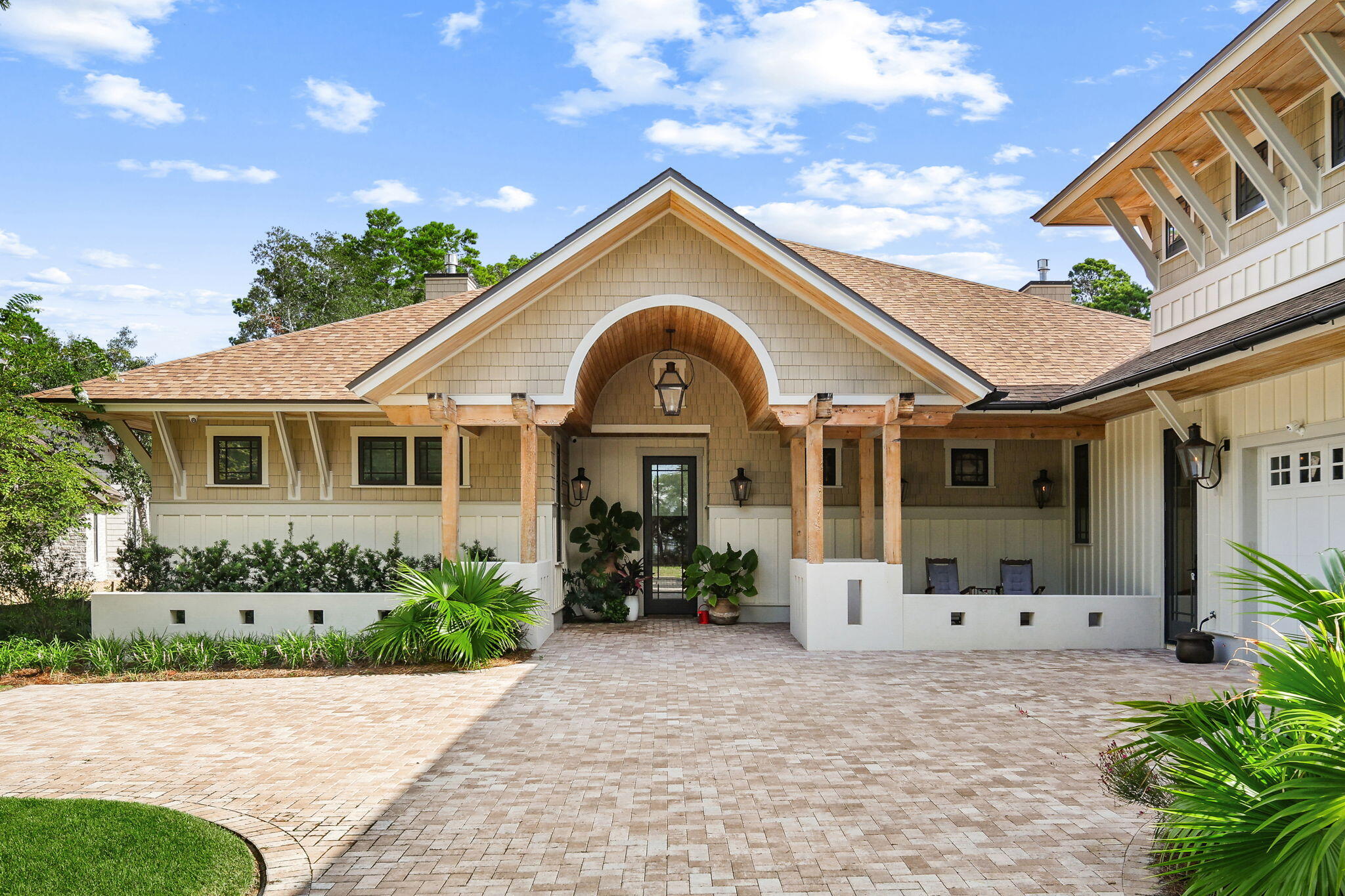 Nestled behind the guarded gates of the exclusive 734-acre Wild Heron preserve, this remarkable Coastal Craftsman estate, masterfully crafted by Regal Stephens, combines unparalleled privacy with world-class design. The exterior immediately commands attention with its striking cedar shake siding, beautifully laid paver driveway, deep exposed-wood brackets, and a dramatic arched entry pavilion. Inside, the home seamlessly blends casual coastal sophistication with meticulous custom millwork, showcasing warm wide-plank hardwood floors, a stunning whitewashed stone fireplace, and a striking tray ceiling wrapped in natural wood beams and blonde wood tongue-and-groove paneling. The chef's kitchen is an absolute showstopper, featuring sleek inset cabinetry, open floating shelving, leathered quartz countertops, an elegant mosaic tile backsplash, a professional gas range under a grand custom hood, a pot filler, and a hidden walk-in pantry behind a crisp white barn door. On the main level, comfort meets luxury with 3 spacious downstairs bedrooms, all comfortably accommodating king beds, two of which feature their own private ensuite bathrooms. This includes the elegant primary suite, complete with a crisp coastal color palette, built-in custom cabinetry, and its own private linear fireplace. Upstairs, a sprawling, versatile secondary living space or guest suite features a built-in kitchenette with a bar sink, beverage fridge, and microwave.  The indoor-outdoor flow is unmatched, leading to a massive, fully screened outdoor living compound backing up to a serene, wooded landscape. This backyard oasis features a resort-style pool and integrated spillover hot tub wrapped in premium travertine decking, luxury in-water lounge chairs, a built-in summer kitchen with a professional-grade DCS grill, and a magnificent tongue-and-groove paneled lanai with a soaring stone-accent wall and linear fireplace. Seamlessly blending into the natural landscape, the backyard layout offers a coveted peek-a-boo view of a tranquil pond, frequently visited by local herons, alongside beautiful views overlooking the 13th hole of the course. Living in Wild Heron means embracing a lifestyle centered on nature and luxury along the shores of Lake Powell, North America's largest coastal dune lake, with world-class amenities including a lakeside resort pool, a fitness center, a boathouse, & firepit. Watersound Club members can enjoy access to the renowned Greg Norman-designed Sharks Tooth Golf Course, clubhouse, & tennis.