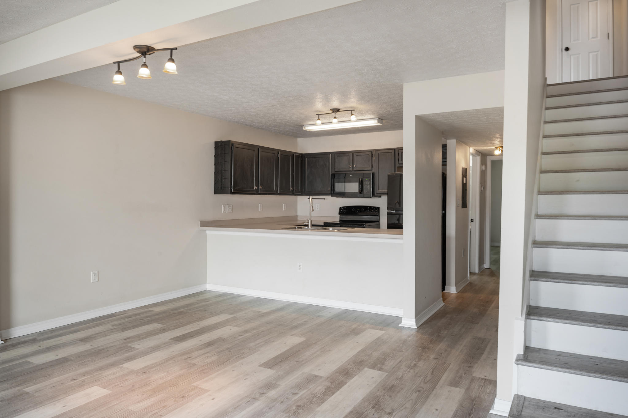 Spacious and inviting, this home features beautiful luxury vinyl plank flooring, oversized bedrooms, and a downstairs primary suite with a sliding glass door leading directly to the back patio. The kitchen is open to the living area, and the fully fenced backyard provides the perfect space for relaxing or entertaining.