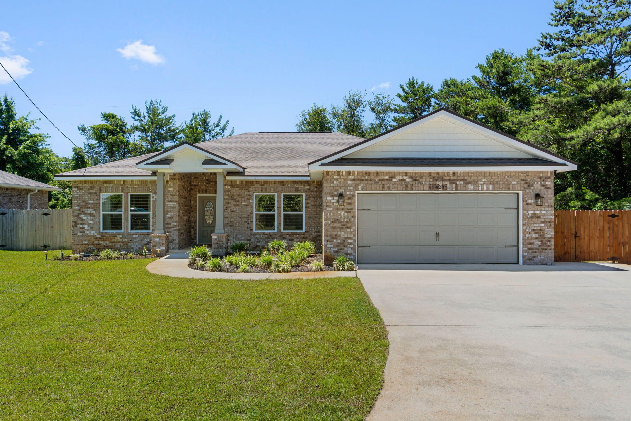 Welcome to this beautifully crafted 4 bedroom, 2 bathroom custom home in the heart of Mary Esther - offering modern design, thoughtful upgrades, and an unbeatable location. Conveniently located near military bases (less than 10 minutes to Hurlburt Field!), schools, shopping, and restaurants, this move-in ready home combines style, comfort, and functionality. Step inside to discover luxury life-proof vinyl plank flooring throughout the main living areas, plush carpeting in the bedrooms, high tray ceilings with accent lighting, crown molding, and modern LED fixtures that create a bright and sophisticated feel. The open-concept layout features a spacious living area and an oversized pantry, while the stunning kitchen is equipped with quartz countertops, stainless steel appliances, shaker-style cabinetry, and a gorgeous tiled backsplash with contemporary drop down lighting. The private primary suite is truly a retreat accented with a tray ceiling and the en suite offers a custom tiled walk-in shower and a huge walk-in closet designed for everyday luxury. Additional upgrades include shaker-style interior doors, a smart front door lock, security alarm system, and cameras for added peace of mind. Enjoy outdoor living with a covered back patio, and a fully fenced backyard complete with an irrigation system. The extended driveway with two additional parking spaces provides extra convenience for guests, boats, or recreational vehicles. If you've been searching for a modern smart home with custom finishes and an ideal location near the Emerald Coast's military bases and beaches, this one checks all the boxes.