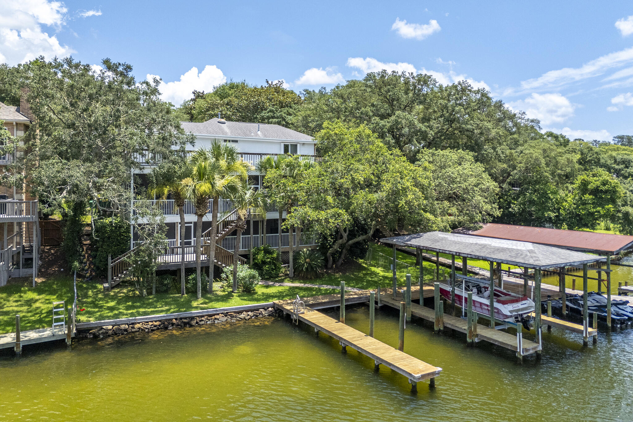 Waterfront Living on the Bayou! This stunning, three-story home offers breathtaking bayou views from private decks on every level, including spectacular panoramic views from the third-floor deck.  The lower level is ideal for guests, featuring a spacious living area, private bedroom, full bath, and abundant storage space, with an office that could also be used as a 5th bedroom. Wine enthusiasts will appreciate the climate-controlled wine cellar complete with a refrigeration unit.  The main living area showcases a spacious great room with a gas fireplace, a beautifully appointed kitchen with a large island, granite countertops, two pantries, and plenty of cabinet space. The expansive main level Master Suite serves as a private retreat with its own fireplace, hardwood flooring, and a luxurious ensuite bath featuring dual vanities, a jetted soaking tub, and a separate walk-in shower.  The third floor offers two additional bedrooms and a full bath, providing plenty of space for family and guests.  Outside, enjoy exceptional waterfront amenities including two large docks, one covered and equipped with a boat lift. Parking is abundant with space for four vehicles, including a detached oversized two-car garage.  A rare opportunity to enjoy waterfront living with space, comfort, and exceptional amenities. Schedule your private showing today!