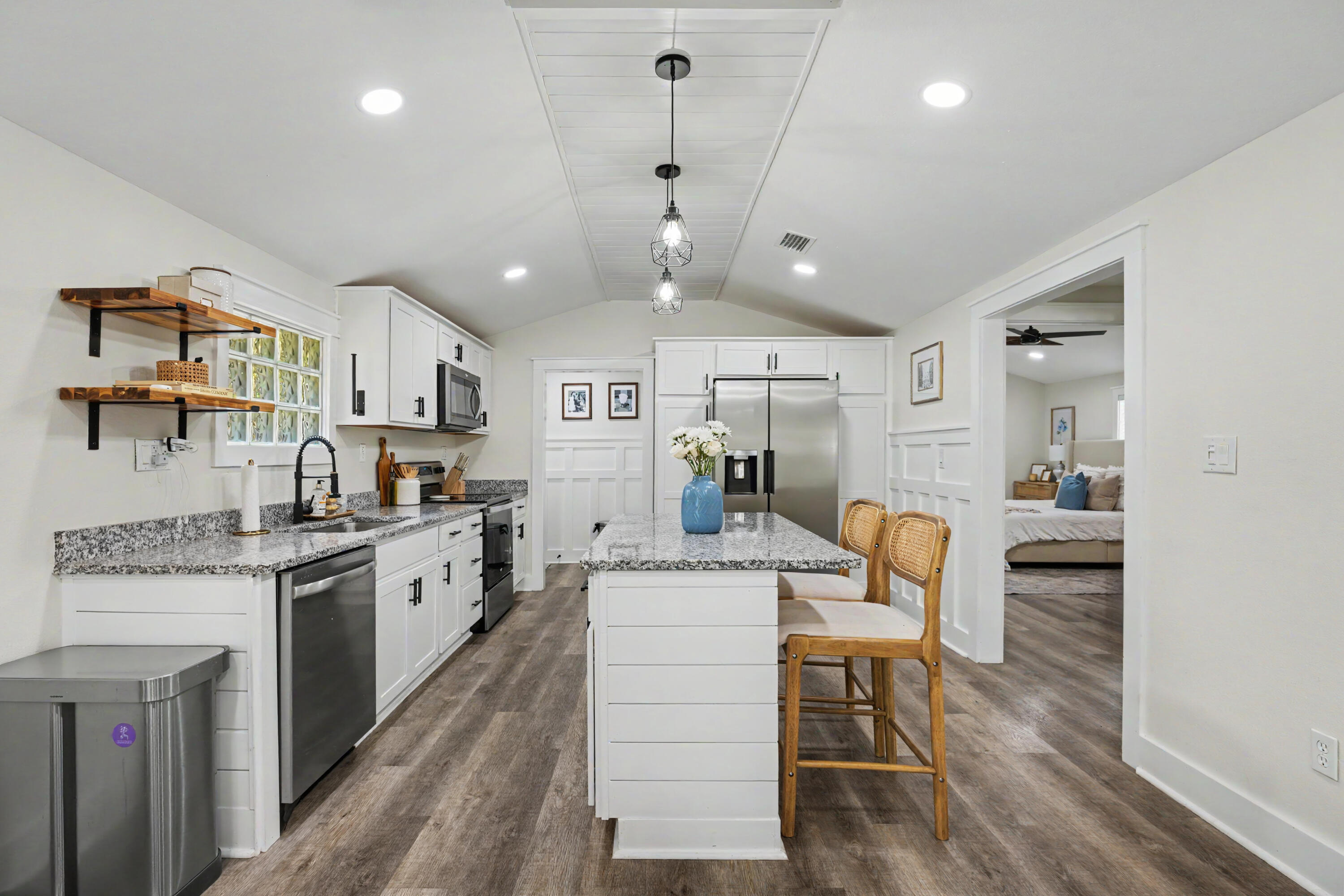 Step into this charming, fully renovated Florida cottage with an effective build year of 2015! Thoughtfully updated throughout, this home feels brand new. Enjoy peace of mind with a 4 year old roof, freshly painted interior, new privacy fence, brand new deck, and added gutters. This 2bedroom, 2bath home exterior features include custom siding, Hardie board, and a storage building. Inside, the open floor plan offers vaulted ceilings and exposed beams. The kitchen includes newer cabinets, granite countertops, stainless steel appliances, and a shiplap island with seating.The master suite boasts vaulted ceilings, shiplap accents, barn doors, and a spacious bath with double vanities and tiled shower. Both baths include Bluetooth exhaust fans. A roomy second bedroom completes this must-see home