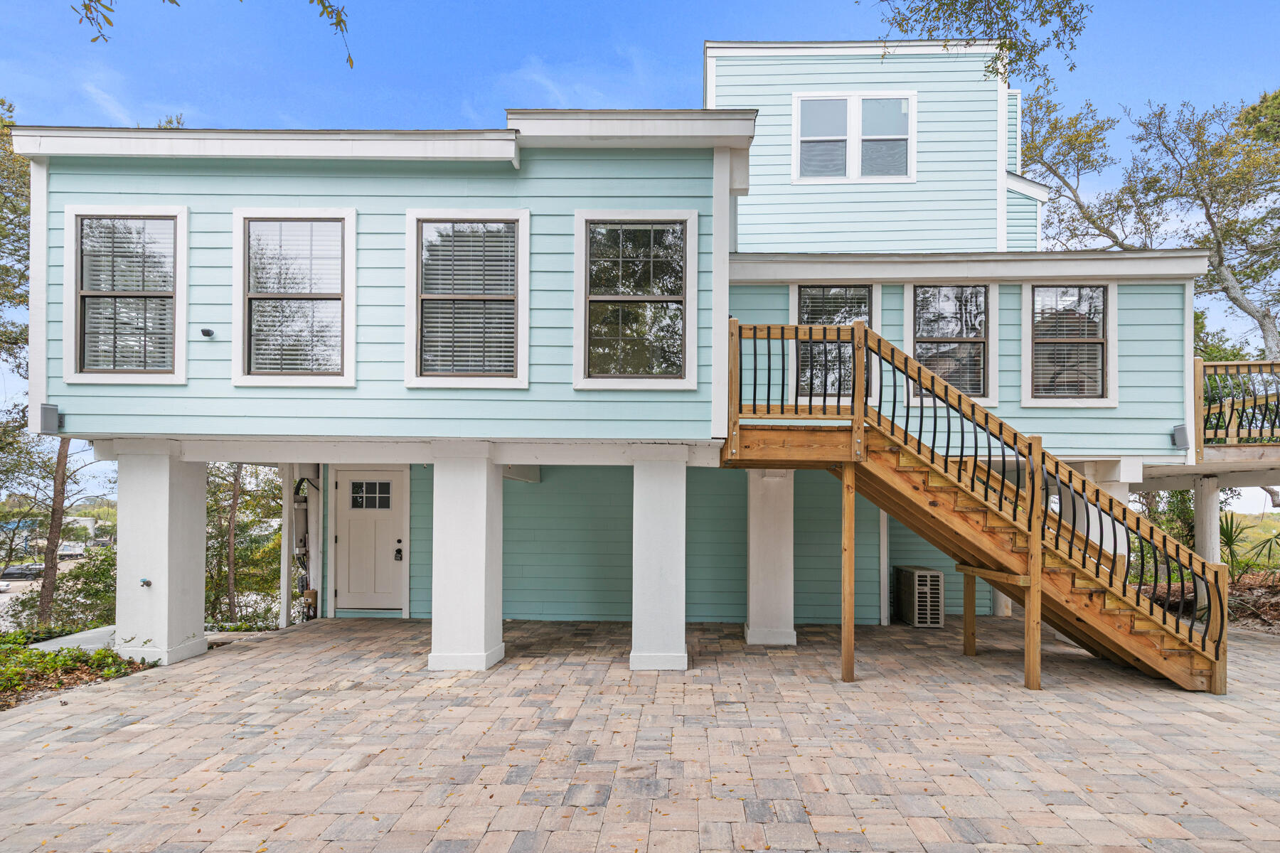 Don't miss out on this rare-to-find renovated home in the heart of Destin that offers a private 'mother-in-law' suite or rental space without the restrictions of an HOA. Nestled in a cul-de-sac lot with one of the highest elevations in Destin, this coastal-contemporary home features a new roof, new kitchens and bathrooms, new ACs, new water heater, tons of natural light, indoor and outdoor spaces on all 3 levels and so much more.  The private ground-floor suite has it's own bedroom, full kitchen, living area, laundry, and separate entrance. The main living levels on the 2nd and 3rd floors offer a bright, open-concept floor plan with vaulted ceilings, skylights, a cozy fireplace, and a large deck for outdoor dining or entertainment. The main Kitchen is equipped with luxury quartz countertops, brand-new stainless-steel appliances, and a breakfast bar. The expansive Primary Suite includes a custom walk-in closet, en-suite bathroom with double vanity, and a versatile bonus room for an office, playroom, or work out space. On the upper floor, you'll find 2 more bedrooms, a full bathroom, a private balcony and even glimpses of the Destin Harbor and Crab Island. The large private driveway is adorned with beautiful new brick pavers that extend around the home creating a shaded outdoor hangout or even a carport beneath the 2nd floor deck. The backyard is designed to be low-maintenance and has a secured room for your paddleboards, lawn equipment, or extra storage. This home is centrally located a few blocks from the Destin Harbor and just minutes from local parks, schools, restaurants, beaches, shopping, and attractions. Please call your favorite agent today to schedule a private showing!