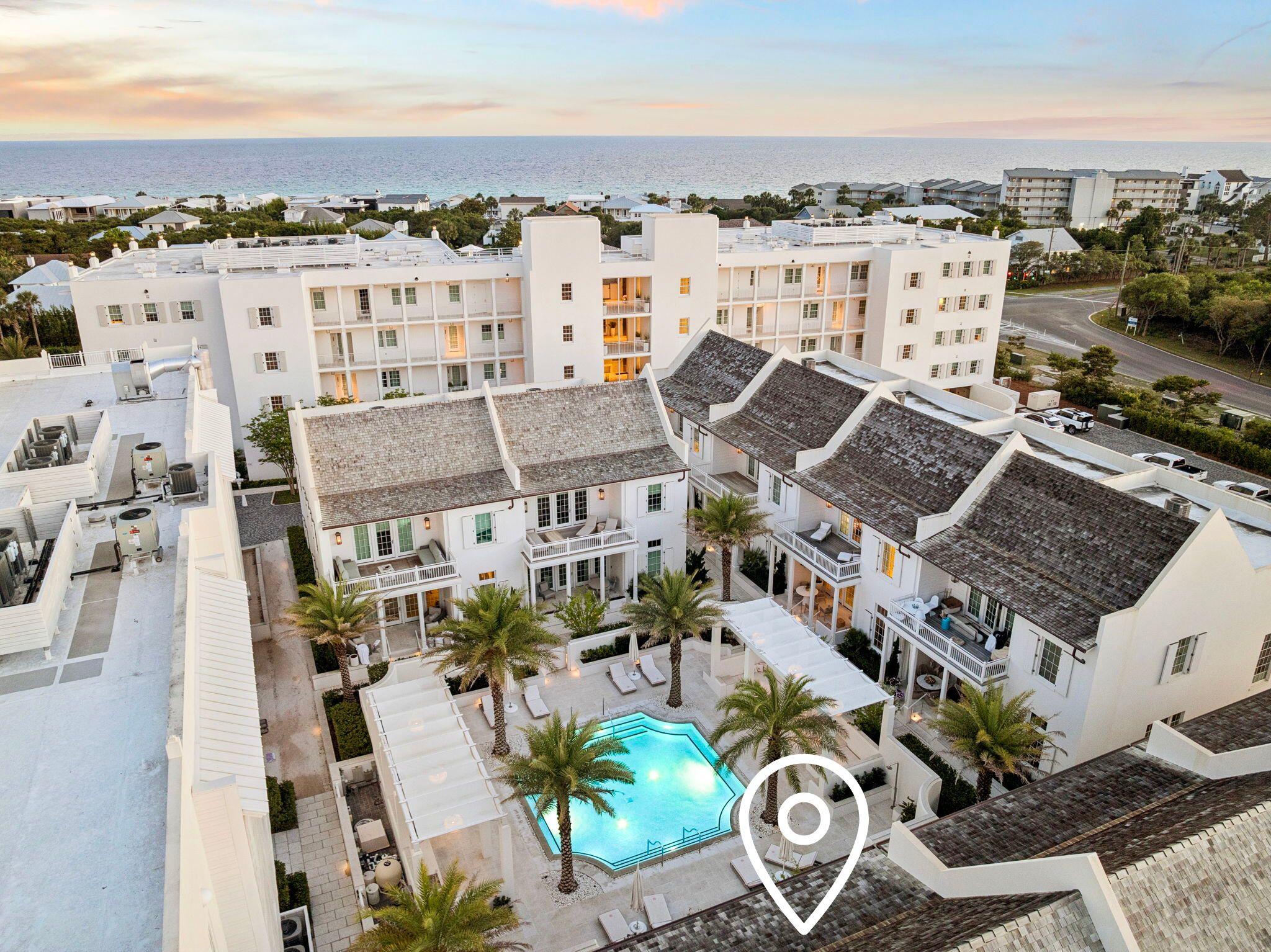 This stunning residence at Kaiya Beach Resort, designed by Khoury-Vogt Architects and Bella Beach Interiors, overlooks the heated pool & is the only Mews residence currently available with direct pool views. The main level features 11-foot ceilings, expansive living & dining spaces, large-format concrete flooring, & a chef's kitchen appointed with Sub-Zero and Wolf appliances, Caesarstone countertops, & custom cabinetry. Every detail reflects refined craftsmanship & understated elegance, from the Waterworks fixtures to the white oak flooring & marble throughout the upper level. The current owner further elevated the interiors with Venetian plaster walls, designer lighting, designer fabric on window treatments, custom bedding, and curated wallcoverings by Phillip Jeffries, Thibaut, and Osborne & Little, adding warmth, texture, and character. Upstairs, 3 spacious bedroom suites and three full marble bathrooms provide privacy & comfort, all finished with the same elevated aesthetic found throughout the residence. Nearly 900 sq ft of covered terraces extend the living space outdoors for poolside views & entertaining. There is an oversized 2 car garage. Mews owners/guests still have access to the private Mews pool, grill area, and beach access without joining the Beach Club. Optional Beach Club membership includes additional  gulf-front infinity pool, rooftop pool at the residences, concierge beach service. Coming soon: 5,000 sq foot spa/gym  and the Lamuse d'or cafe!
