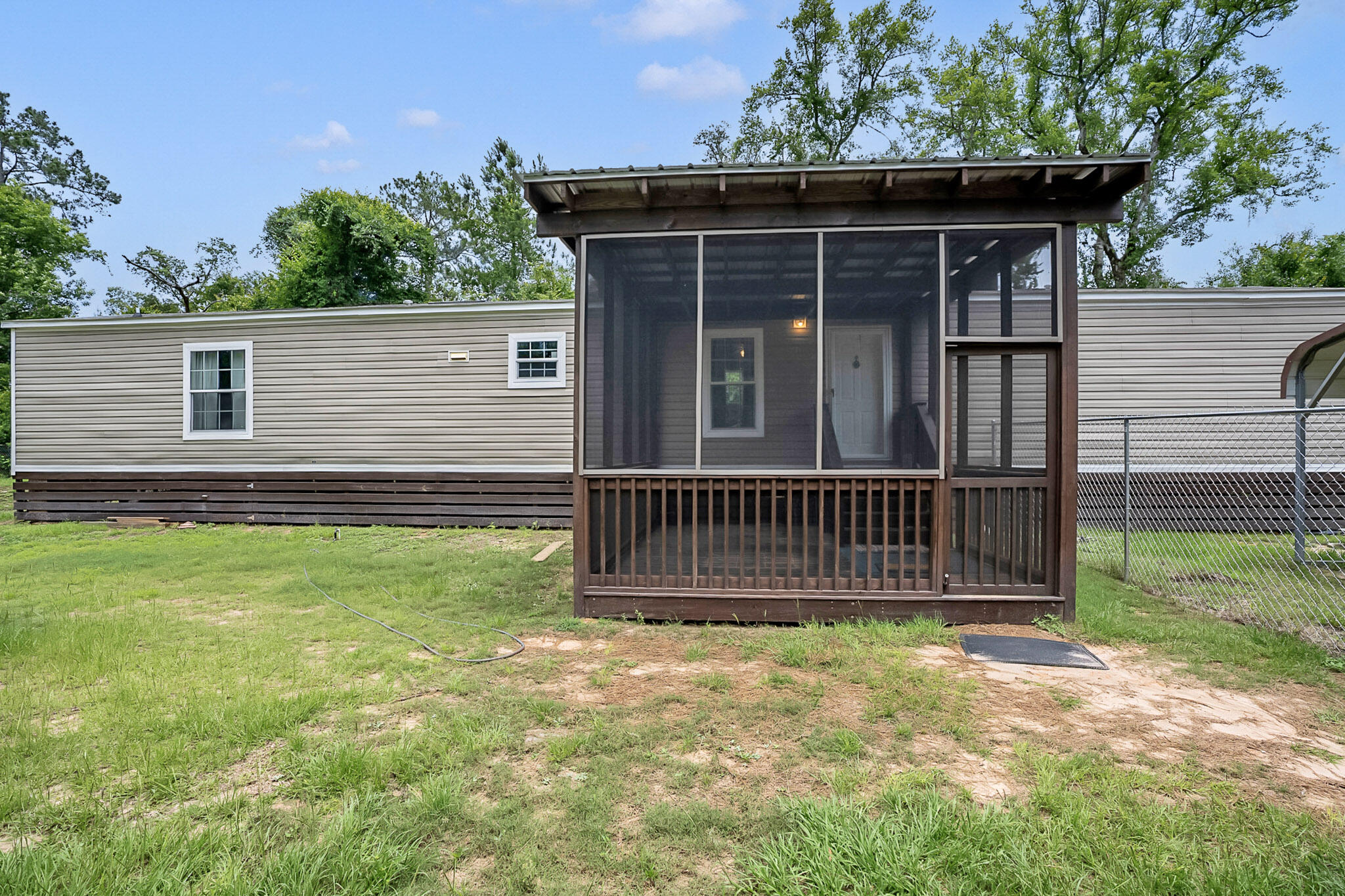 A Fisherman's Dream! Nestled in the highly sought-after Black Creek Fish Camp area, this charming 2022 manufactured home offers convenient access to Black Creek, Jolly Bay, and the Choctawhatchee River and Bay--making it the perfect retreat for boating, fishing, and outdoor enthusiasts.  This well-maintained 3-bedroom, 2-bath residence features an inviting open-concept floor plan with durable luxury vinyl plank flooring throughout the main living areas and comfortable carpeting in the bedrooms. The spacious primary suite includes a walk-in closet and an ensuite bath with dual vanities. The kitchen showcases rich brown cabinetry, attractive countertops, and a decorative faux wood beam that adds warmth and character while defining the kitchen and living spaces. 
Additional conveniences include a generously sized laundry room and a covered carport with ample space for your vehicle or boat. Recent upgrades enhance both comfort and functionality, including a beautiful screened-in front porch--perfect for enjoying morning coffee or relaxing in the coastal breeze--and a new 8' x 10' wooden storage shed for all your gear and equipment.