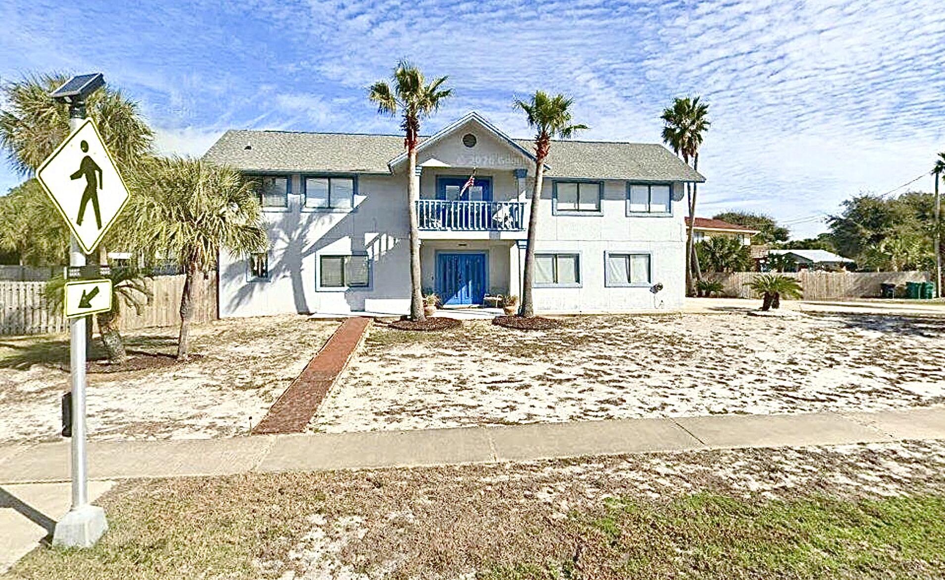 Steps to the shore! Located directly across from beach access--under 150 yards away--this coastal retreat offers the ultimate beachside lifestyle. The main level features an expansive, open-concept living, dining, and kitchen area with vaulted ceilings, custom built-ins, and a built-in desk. The modern kitchen boasts stainless steel appliances and a breakfast bar. Relax in the main-level primary suite with a large walk-in closet and luxury bath. Outside, a spacious wrap-around balcony captures refreshing Gulf breezes and overlooks a beautifully fenced backyard. The ground level adds excellent versatility with a den, two additional bedrooms, a full bath, and a double side-entry garage.