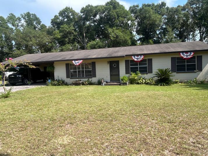 Summertime and the living is easy in small community area with 2 acres and a block home. This property might be exactly what you've been looking for! Home is situated along a paved road, just a short distance from Morrison Springs and easy access to I-10 as well as beaches.  Home has shingle roof, an attached two-car carport, and  outbuildings.  Metal workshop 30x16., Shed is 12x16.  Two car metal awning. Chain-link fenced back yard. Home has been well-maintained but requires some updates. It includes a large living room, a screened in patio, formal dining room, 3 bedrooms and two full baths. LVP and carpet floor covering. Grounds are well groomed and trees for shade. Schedule an appointment to see!