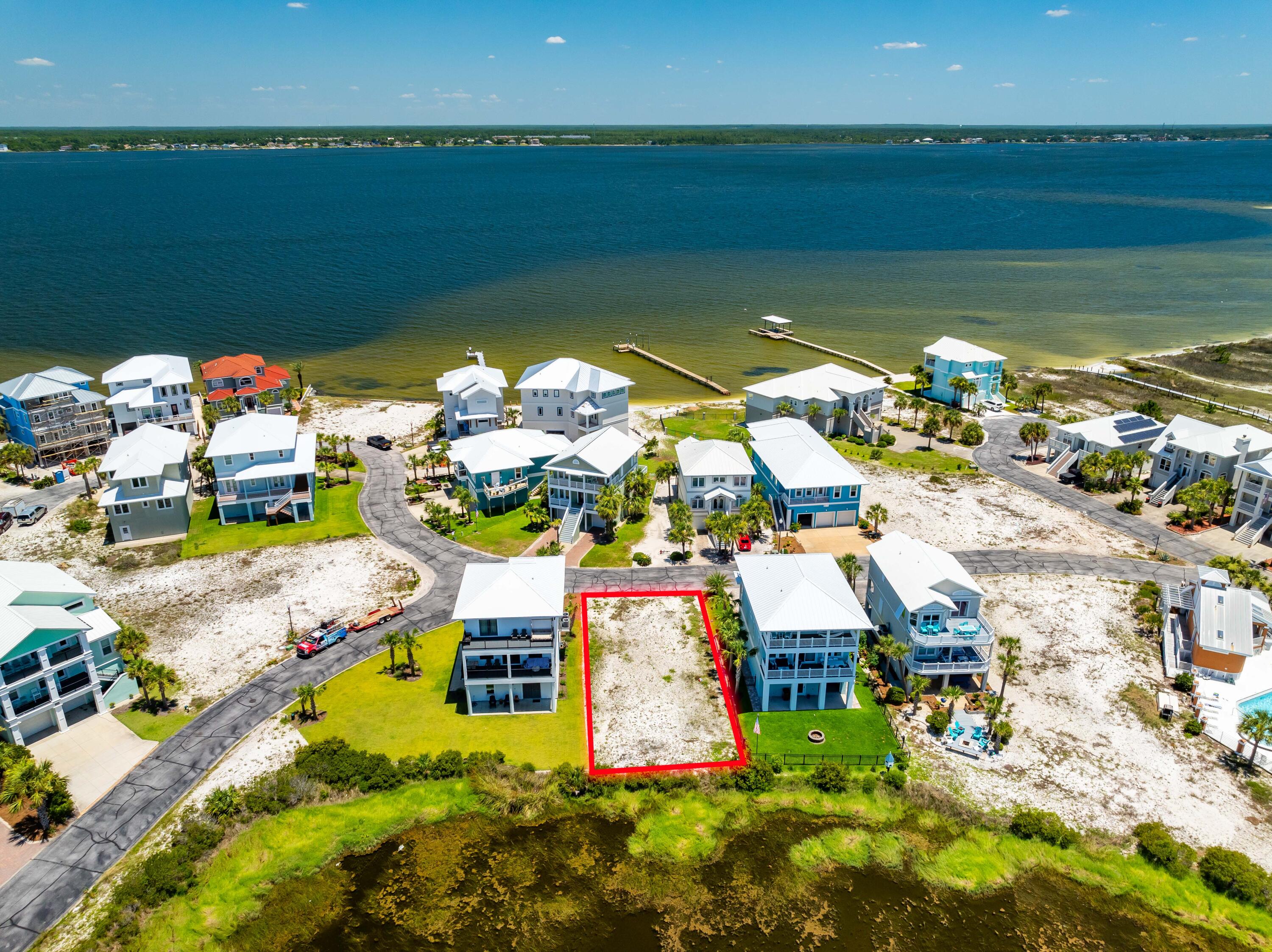 Large 50' x 99' Lot Bordering a Natural Pond within tranquil Gated Community of Caribbean Isle. Lot 4 Blk C is One of only five lots that it Backs Up to a Community Pond Area within the community ensuring no one can build directly behind you. This fantastic feature guarantees privacy and peace while highlighting the area's natural beauty. Experience the serenity of being surrounded by nature, yet remain part of a vibrant and desirable community. The lot also offer potential Santa Rosa Sound and Gulf Views for your future home. 
Caribbean Isle offers a variety of amenities for residents & guests to enjoy, including tennis courts, a gated entrance for added privacy and a sparkling community hot tub + swimming pool...it is Florida after all! Navarre Beach is one of the last areas with an .. "Old Florida" appeal and a Fantastic Place to Live and Own a Piece of Paradise as either Secondary/Investment or Primary Home. Navarre Beach has Miles and Miles of White Sandy, Crowd Free Beaches, and Stunning Emerald Hued Waters. There's plenty of Leisure Activities to enjoy whether on the Gulf of Mexico or the Santa Rosa Sound, with Parks, Hiking/Biking Paths, and the Spectacular Gulf Islands National Seashore. Just over the National Seashore is Pensacola Beach for even more Entertainment, Shops, and Restaurants.