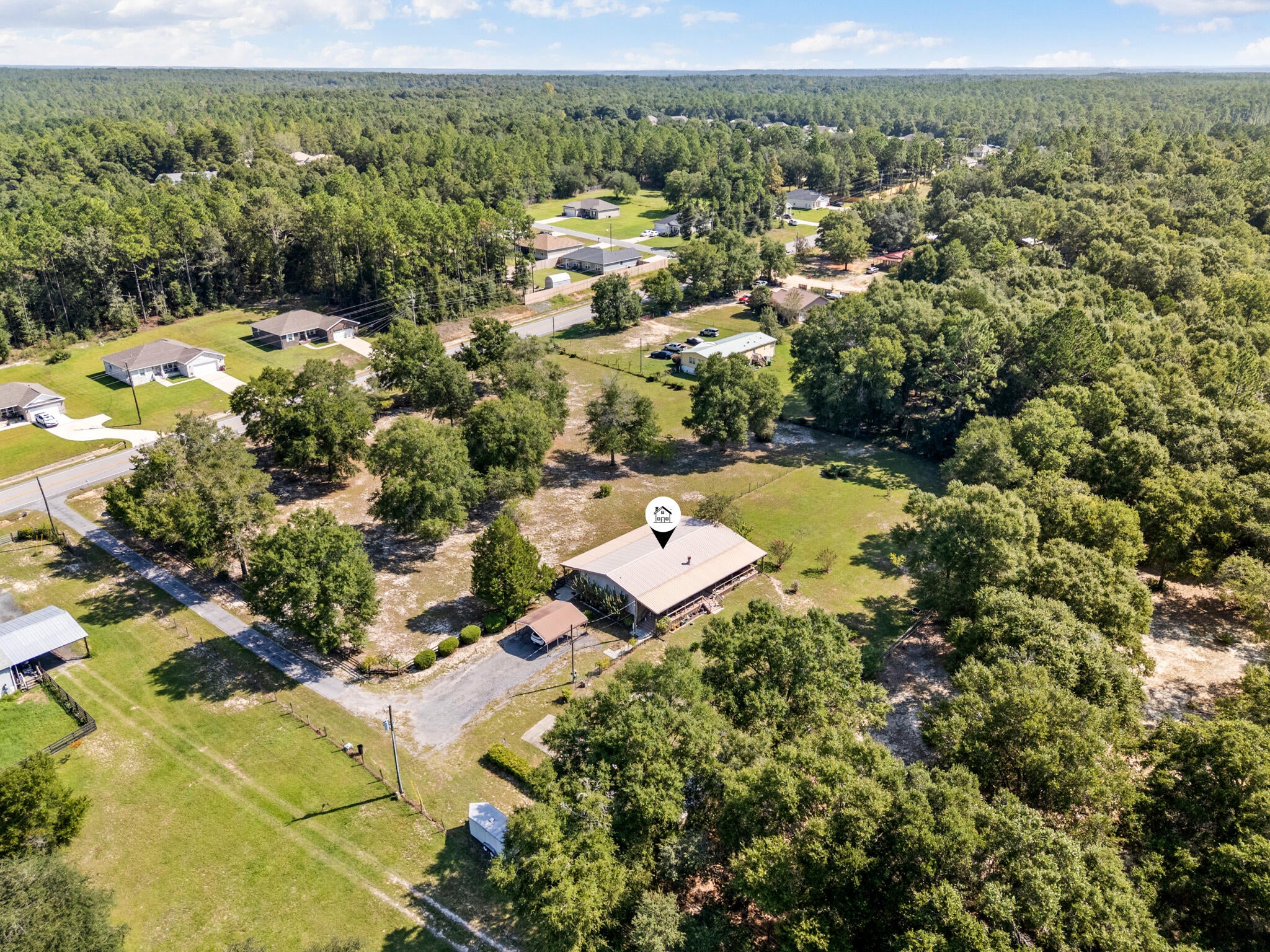 Welcome to 3930 Poverty Creek Road, a meticulously maintained, one-owner double-wide manufactured home situated on 2.6 beautiful acres that have been lovingly cared for as a homestead for nearly three decades. Offering 1,800 square feet with three bedrooms and two full bathrooms, this property combines a well-kept home, substantial improvements, and the kind of usable land that is increasingly difficult to find.

A long paved driveway leads into the fully fenced property, where approximately 326 feet of road frontage, mature scattered trees, established landscaping, and tall woods along one side create a peaceful and private setting. Farm-style post-and-rail fencing adds to the property's rural character without obstructing the view. Full-length covered porches extend across both the front and back of the home, providing an exceptional amount of outdoor living space. The hot tub located on the back porch will also convey.

Inside, new luxury vinyl plank flooring extends throughout the entire home. The spacious, semi-open kitchen offers an enormous amount of cabinet space, a center island, brand-new appliances, and a propane range. The adjoining living area features a working fireplace. The split-bedroom floor plan places two secondary bedrooms on the opposite side of the home from the generously sized primary suite. The primary bathroom includes a garden tub, separate shower, double vanity, and an exceptionally large walk-in closet.
 Major improvements include a new HVAC system and water heater installed within the past two years, updated electrical completed less than one year ago, and newly replaced and permitted plumbing beneath the home. The metal roof was replaced within the past eight years. Multiple working water spigots are positioned from the home to the far corners of the property, providing convenient water access throughout the acreage.

Additional features include a carport with a brand-new EV charger, dedicated RV parking with an electrical hookup, multiple outbuildings, and plenty of open, usable ground. With 2.6 acres, the property offers room for a future detached garage, workshop, or even an additional residence, subject to applicable zoning and permitting. After nearly 30 years as a carefully maintained homestead, this property is ready for its next owner to continue that story and make full use of everything the land has to offer.