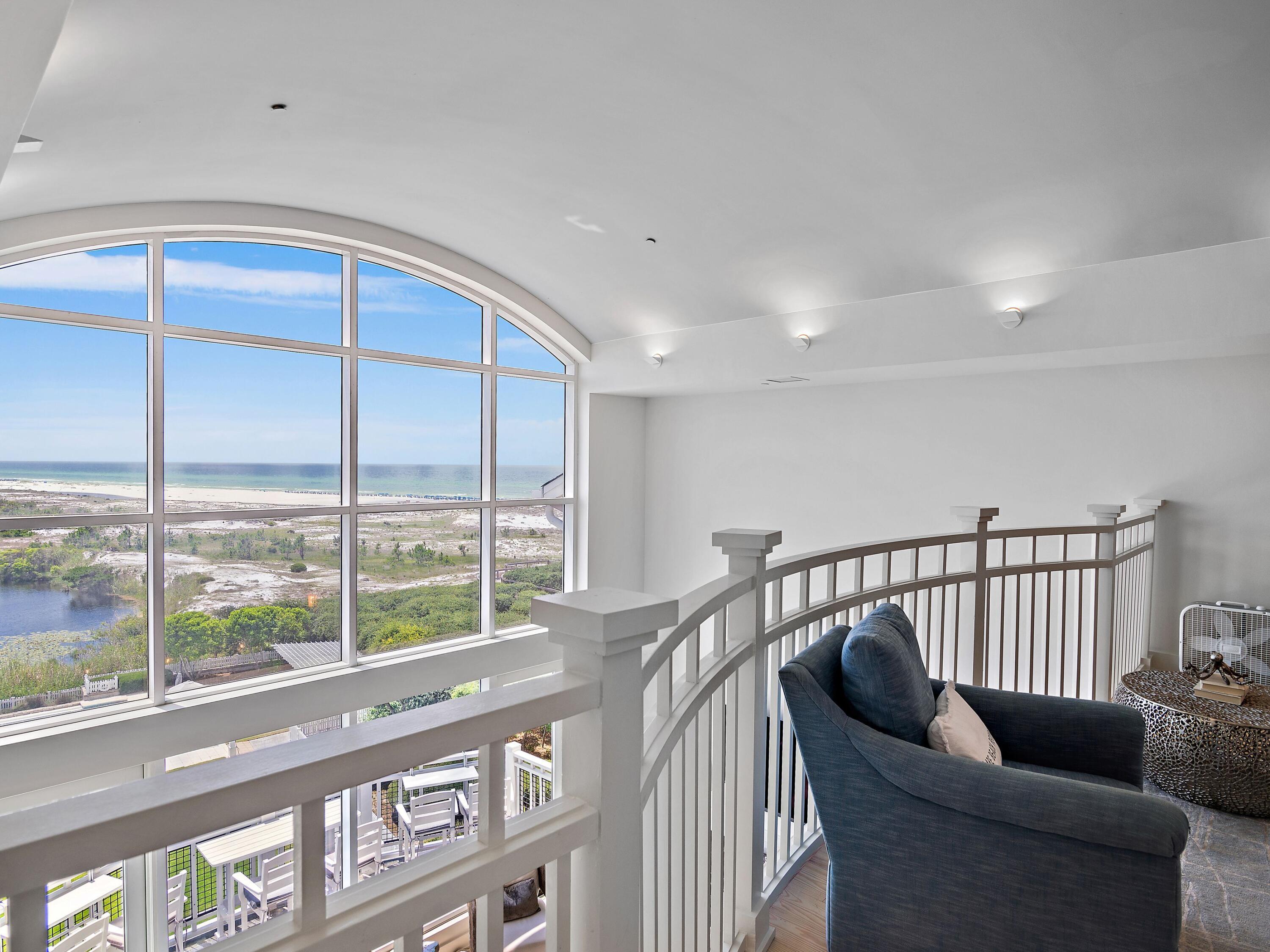 This gulf-facing condominium in WaterSound Beach breaks away from traditional coastal design and delivers a dramatic architectural statement centered entirely around light, space, and sweeping views. Positioned high above the rare coastal dune lakes, this luxury residence offers unobstructed Gulf and lake vistas through soaring two-story windows that flood the interior with natural light. The main living area features 20-foot ceilings and an open layout that seamlessly connects the sitting area, dining space, and a newly reimagined kitchen—each framed by breathtaking coastal scenery. Step onto the private balcony to feel the Gulf breeze and take in the ever-changing water views, from sunrise to sunset. Completely renovated to the highest standard, the condo showcases fresh coastal finishes, custom lighting, and new paint throughout, creating a crisp, modern aesthetic. Three new HVAC systems provide comfort and efficiency year-round. The main level includes a guest bedroom and an updated bathroom with a tiled shower, ideal for visitors. The chef's kitchen is both stylish and functional, featuring new custom cabinetry, quartz countertops, and premium appliances, including a Viking refrigerator and range, plus a Bosch dishwasher. A built-in bar creates a natural gathering spot for evening cocktails, while the dining area comfortably seats six.  A mezzanine loft overlooks the living space below, offering a flexible bonus area with a sleeper sofa and TVperfect for additional guests or a relaxed lounge. The open railing preserves sightlines to the Gulf, keeping the views front and center. On the lower level, a guest suite with an updated walk-in shower bath provides privacy and comfort. Just beyond the laundry area, the primary suite is a true retreat, featuring its own sitting area, a completely redesigned spa-style bathroom with a freestanding soaking tub, seated vanity, and fully tiled walk-in shower. The primary suite also opens to a private balcony, ideal for morning coffee or quiet evenings with a book. Offered fully furnished with a proven rental history, this residence is perfectly suited as a luxury investment property, second home, or full-time coastal residence. A detached garage provides valuable storage for golf carts, beach gear, and bicycles. Residents enjoy access to WaterSound's premier amenities, including private beach access, multiple pools, golf, tennis and pickleball courts, a wellness center, dining, and boutique shoppingoffering a refined coastal lifestyle unlike anything else on 30A.