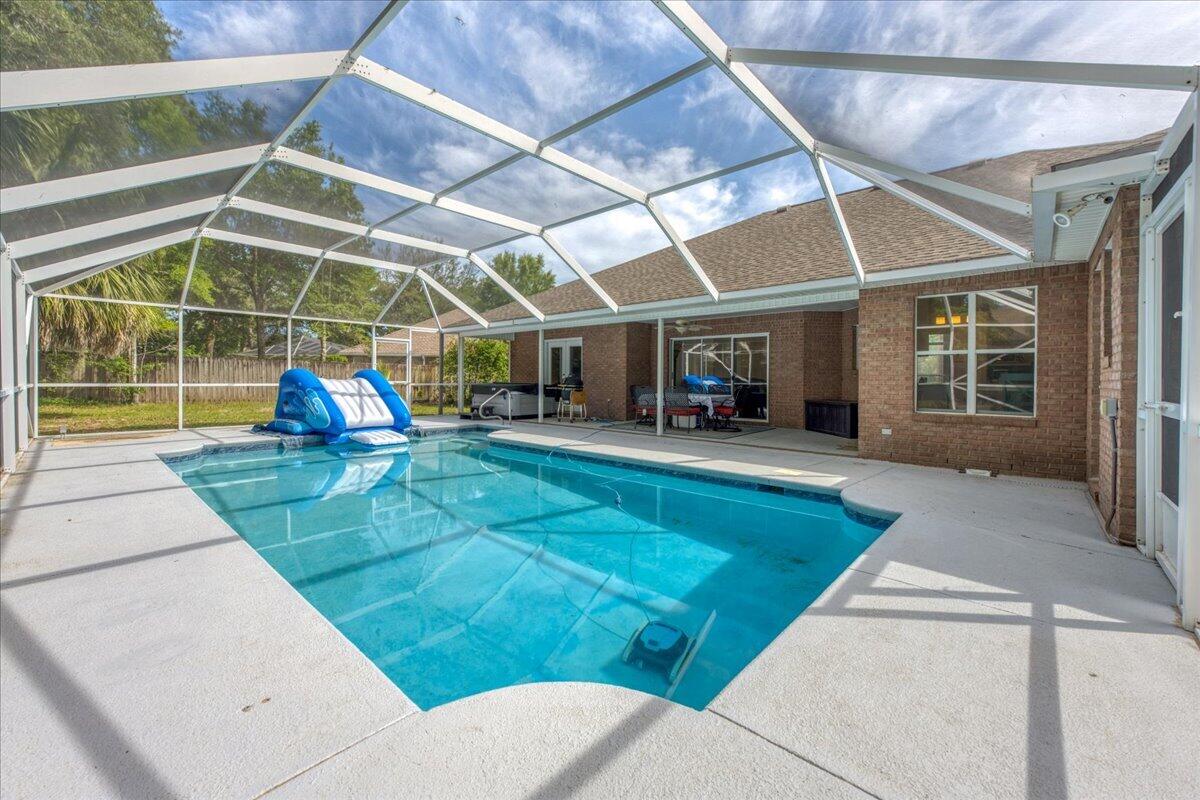 Welcome to Rocky Bayou Country Club Estates. This home offers a perfect balance of open, connected spaces and private retreats. It is effortlessly designed for both quiet, family routines and large-scale entertaining. Smart Split Layout: The private master suite is tucked away in its own wing. Two guest bedrooms share a quiet hall wing, and the fourth bedroom sits at the rear--featuring its own dedicated bath with direct pool deck access (no wet feet tracking through the house). The spa-like master bath features separate dual vanities, a deep jetted soaking tub, and a freshly tiled walk-in subway shower. Two distinct living spaces feature an airy, pool view family room or a cozy second den centered around a gas fireplace with a custom mantle. There is elegant crown molding, thick trim accents, and sophisticated tray ceilings in the dining room and master suite. The kitchen is outfitted with granite countertops, a breakfast bar, and a charming and sun filled dining nook. There are stainless steel appliances (including a French-door refrigerator and a Jenn-Air cooktop). The backyard has a  bright, main living area looking out over a pristine, in-ground gunite pool fully protected by a screened enclosure. There is a full-brick exterior with modern stucco accents, a side-entry courtyard garage and is located on a small cul-de-sac in one of Niceville's most established neighborhoods. *Outdoor hot tub does not convey*
*Sprinkler system conveys as is*
*Pool was resurfaced in 2023*
*Pool does have an electric pool heater*