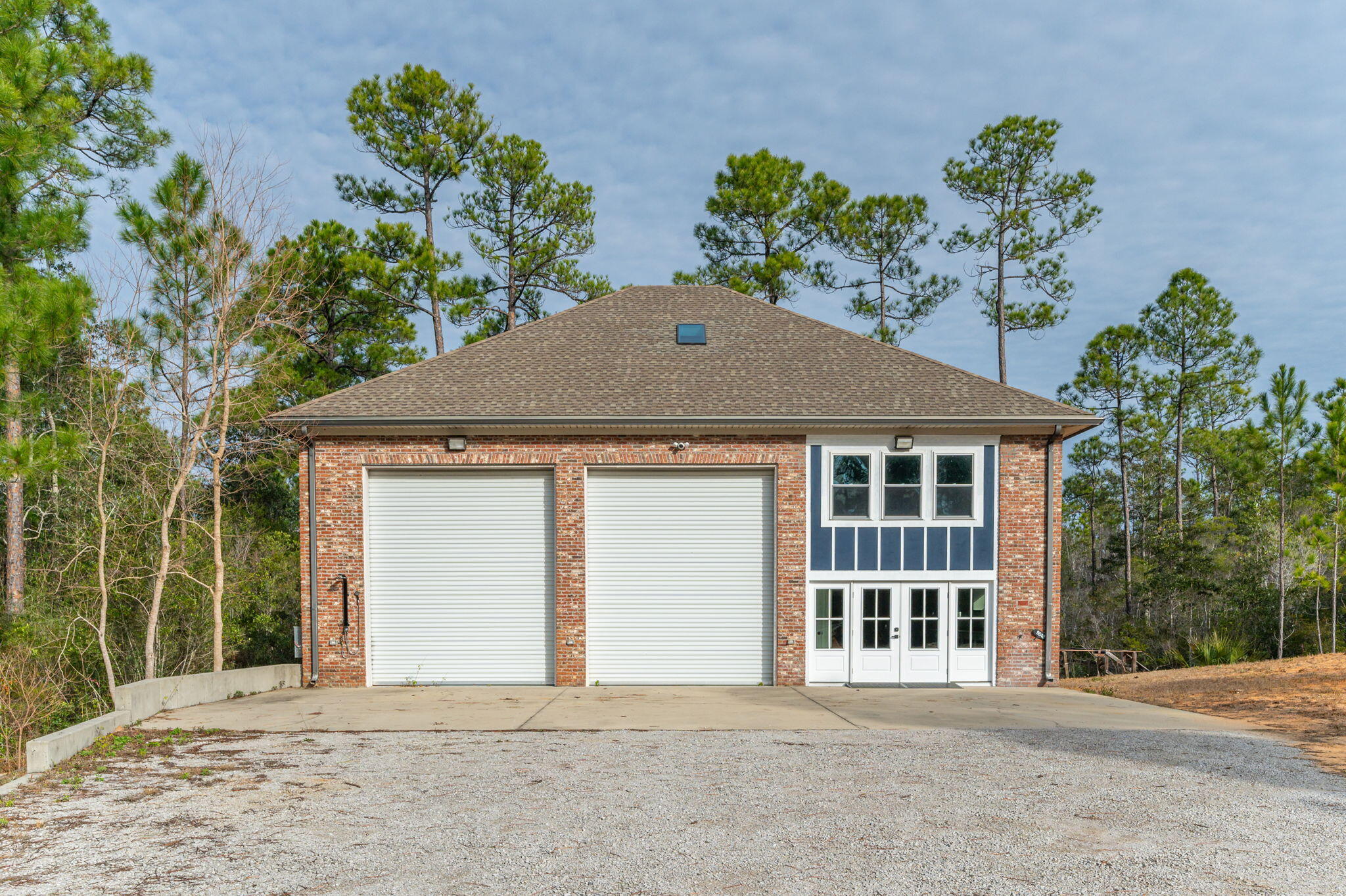 Explore the extensive possibilities at 9648 Bone Bluff Drive, a generous 5.16-acre property situated in Navarre's established Whispering Pines Estates neighborhood. This remarkable property offers a unique blend of space, versatility, and modern convenience, making it an ideal retreat for a variety of lifestyles. This double lot features 208' of water-frontage along the East Bay River and encompasses a mix of pristine natural wetlands and cleared areas, providing a serene backdrop for outdoor enthusiasts. While the building was originally constructed as a massive 41' x 48', custom 3-bay garage in 2011 by Randy Wise Homes, the current owner greatly enhanced the interior in 2023 by adding a contemporary 2-bedroom, 2-bathroom apartment. Upon entering the residential side of the building,